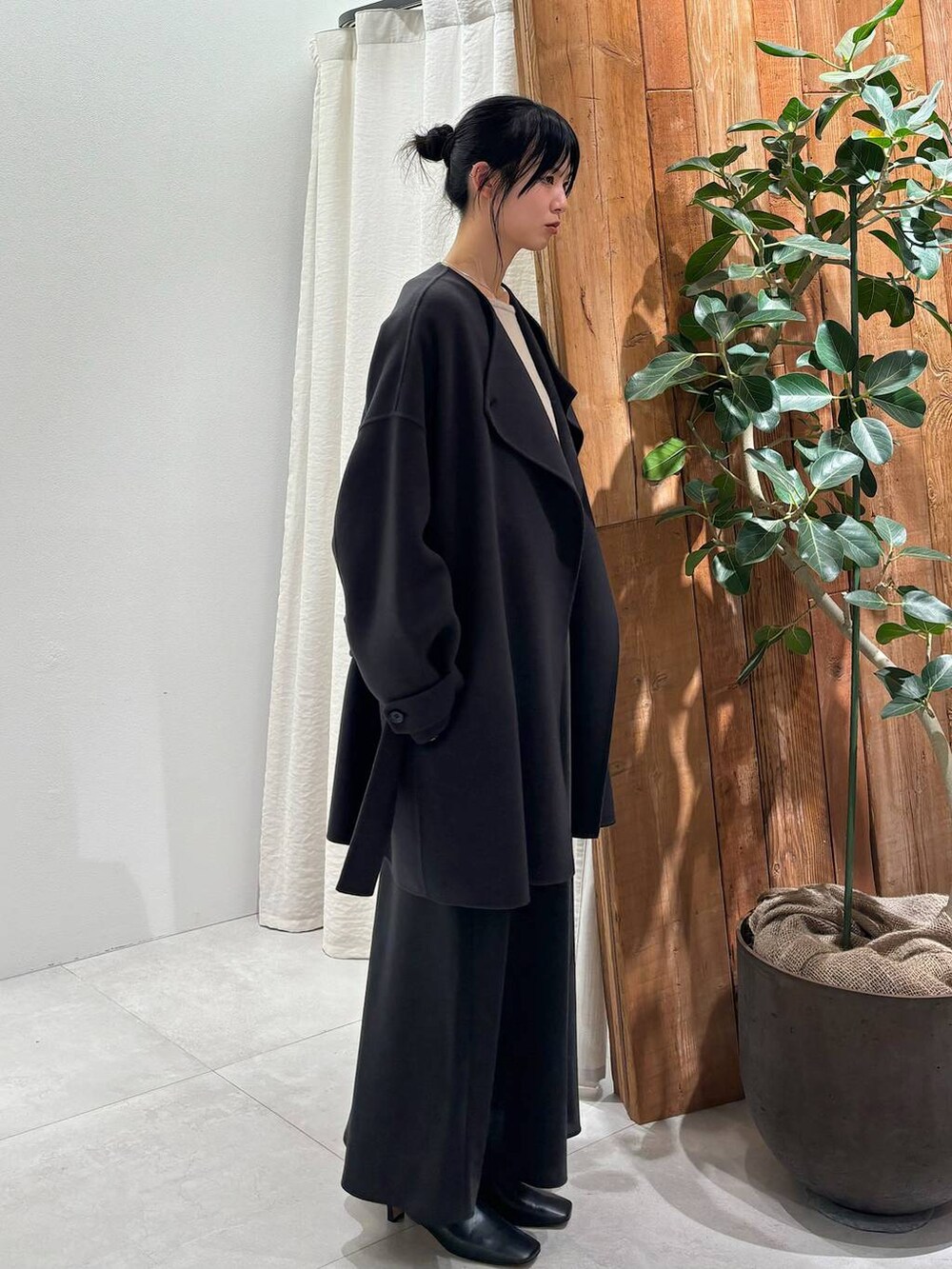 グレー系のニット/セーター、グレー系のピーコート、ブラック系のスカートを着用したレディースの秋コーディネートの3枚目の写真