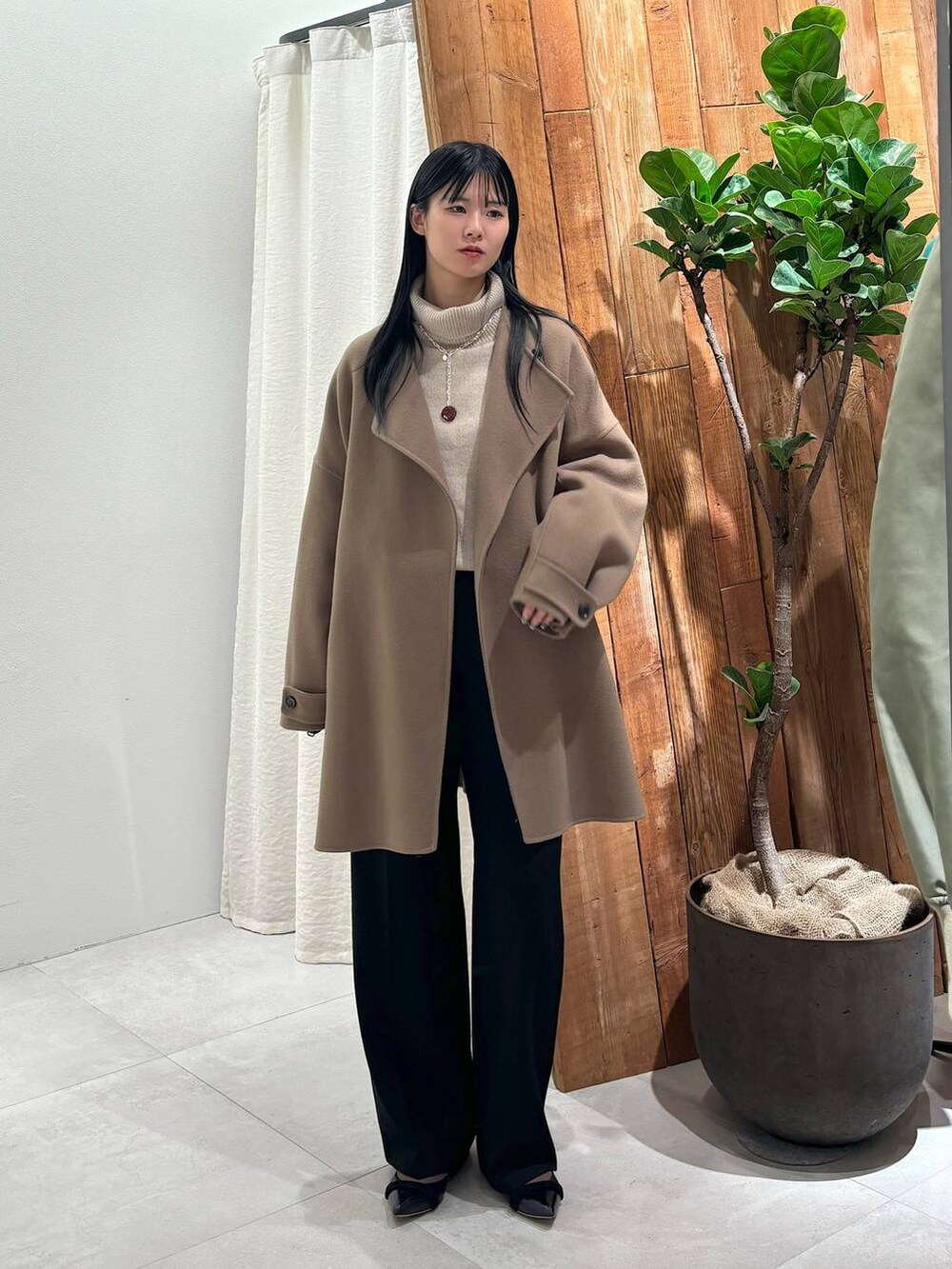 ベージュ系のニット/セーター、グレー系のピーコート、ブラック系のその他パンツを着用したレディースの秋コーディネートの5枚目の写真
