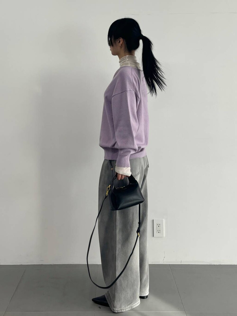 ホワイト系のTシャツ/カットソー、グレー系のデニムパンツ、パープル系のニット/セーターを着用したレディースの冬コーディネートの3枚目の写真