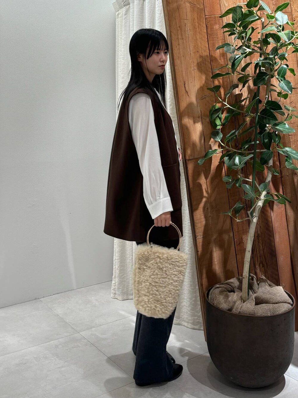 ホワイト系のハンドバッグ、ブラウン系のその他アウター、ホワイト系のシャツ/ブラウスを着用したレディースの秋コーディネートの2枚目の写真