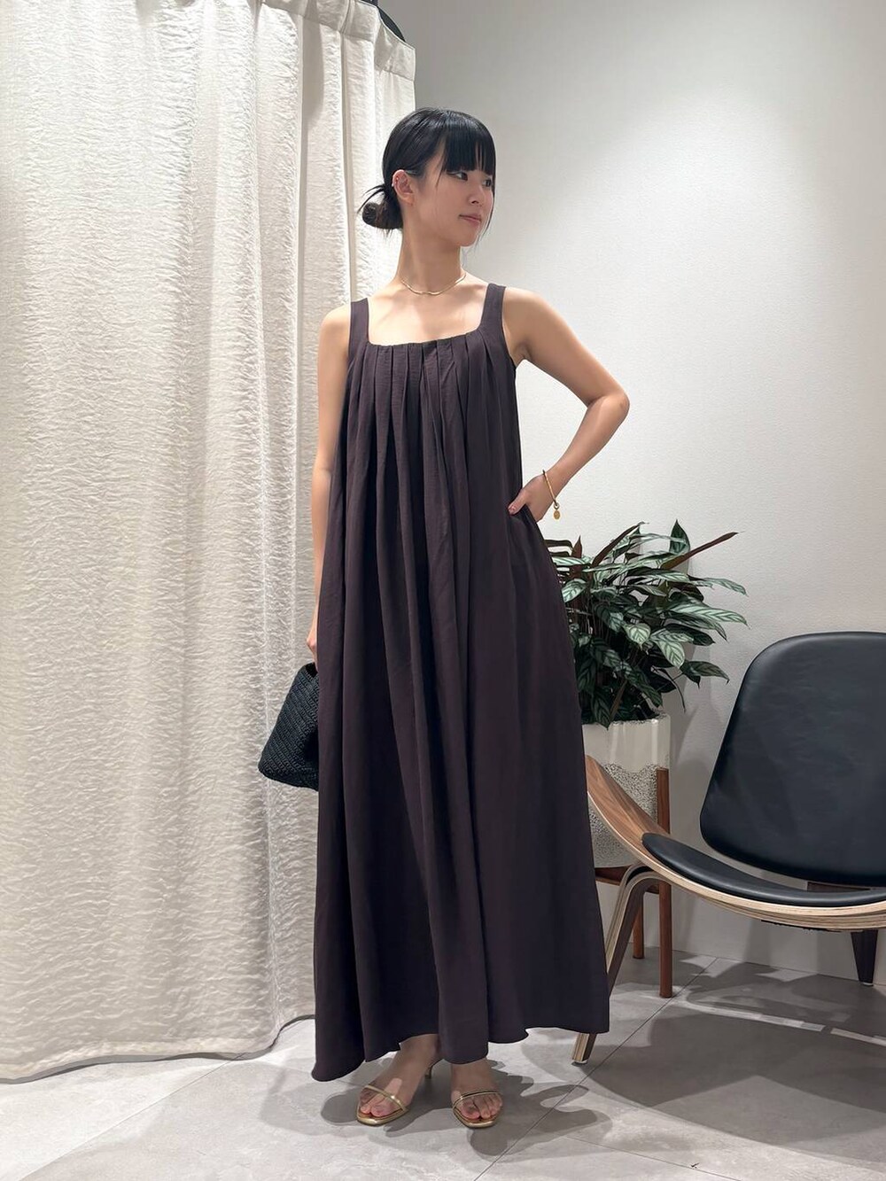 ブラウン系のワンピース、ゴールド系のサンダル、ゴールド系のブレスレットを着用したレディースの春コーディネートの4枚目の写真