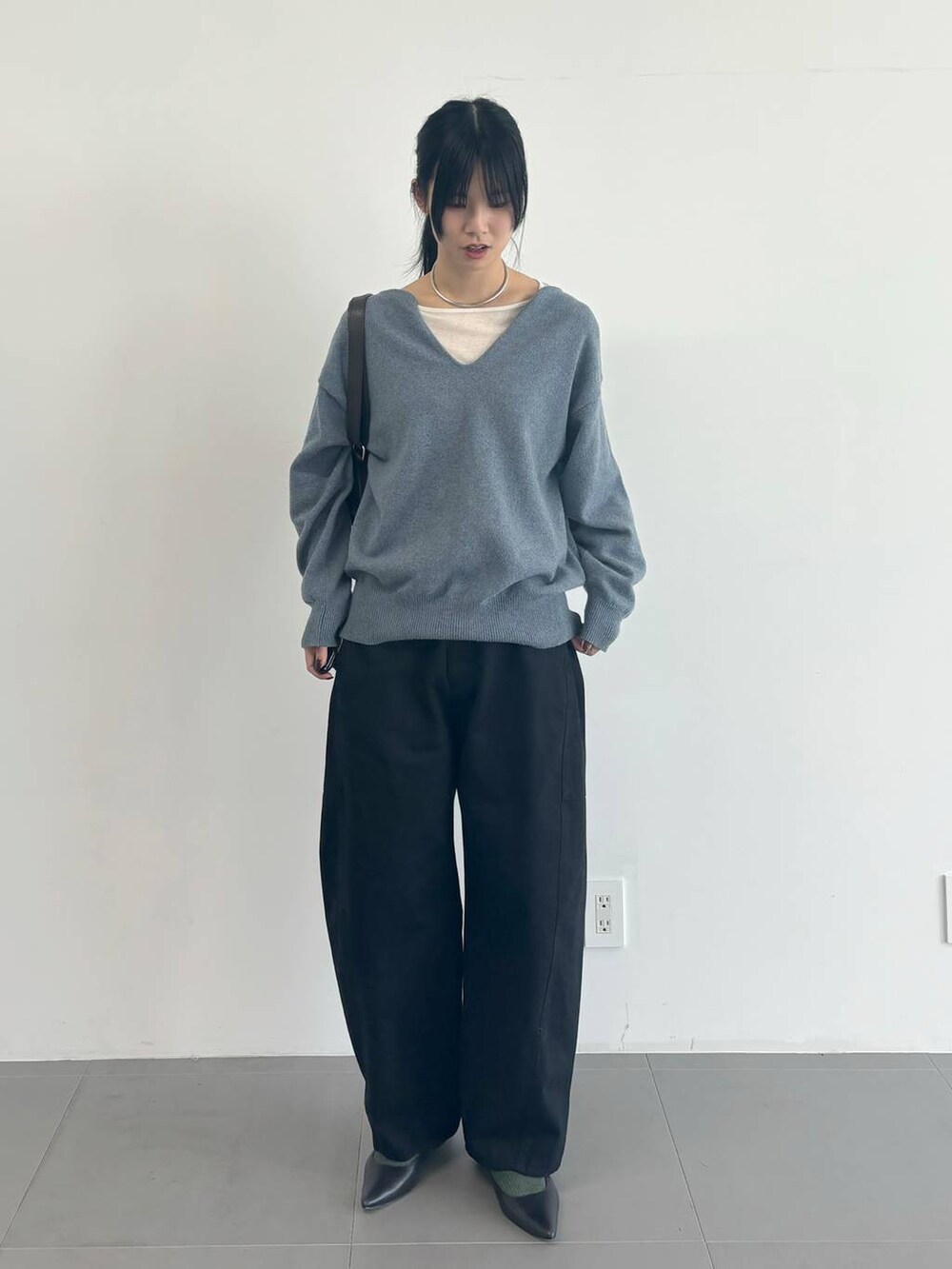 ホワイト系のTシャツ/カットソー、ブルー系のその他パンツ、グレー系のニット/セーターを着用したレディースの冬コーディネートの4枚目の写真