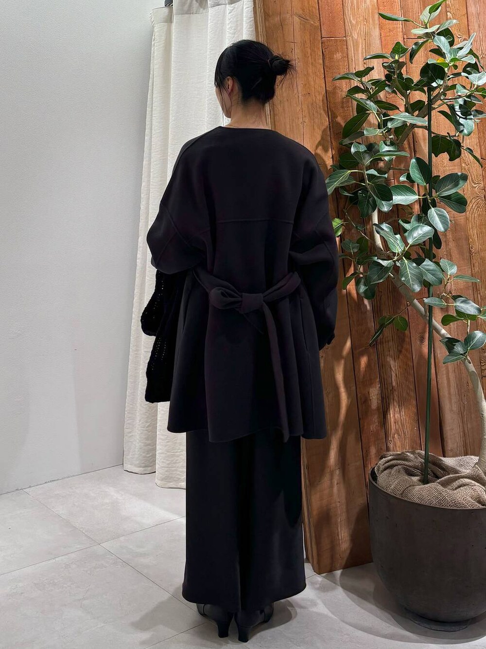 グレー系のニット/セーター、グレー系のピーコート、ブラック系のスカートを着用したレディースの秋コーディネートの4枚目の写真