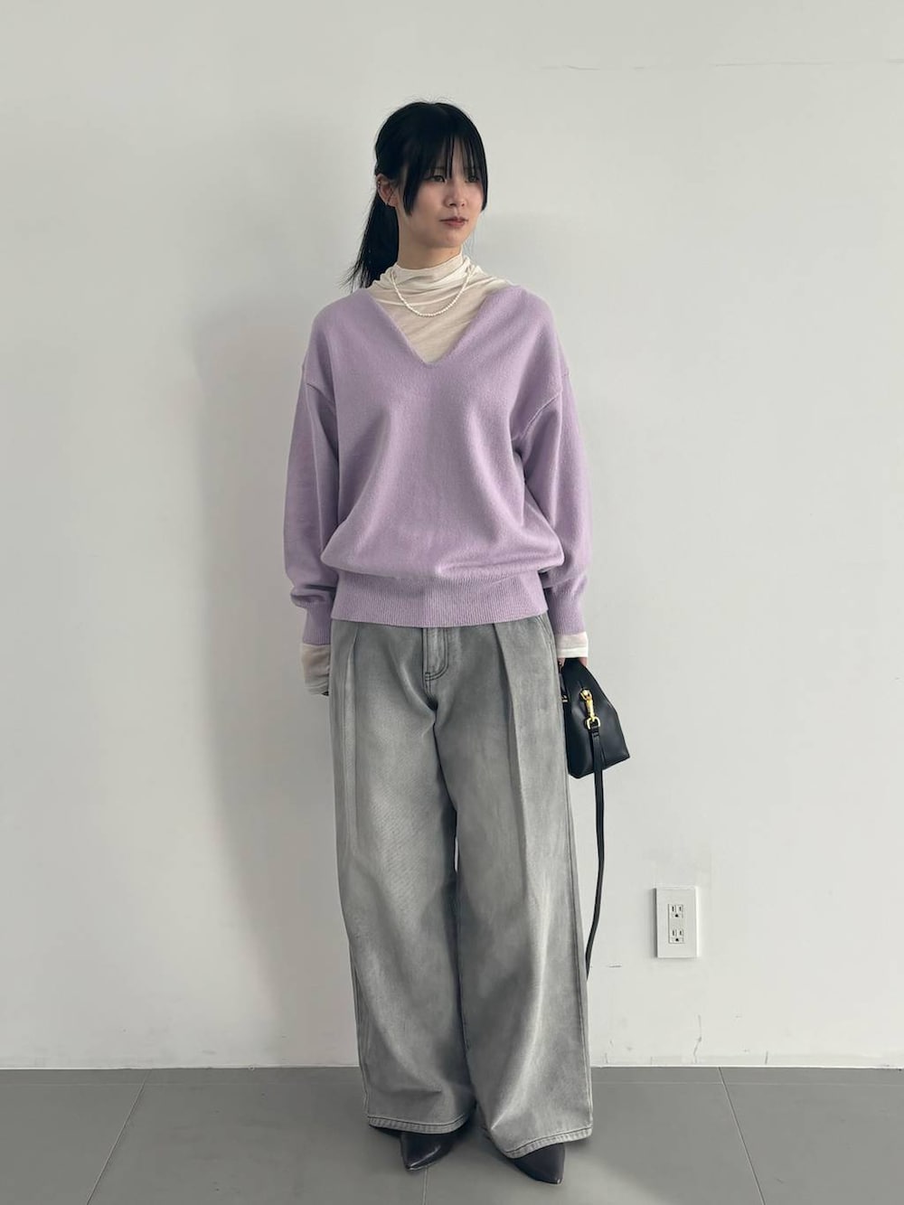 ホワイト系のTシャツ/カットソー、グレー系のデニムパンツ、パープル系のニット/セーターを着用したレディースの冬コーディネートの5枚目の写真