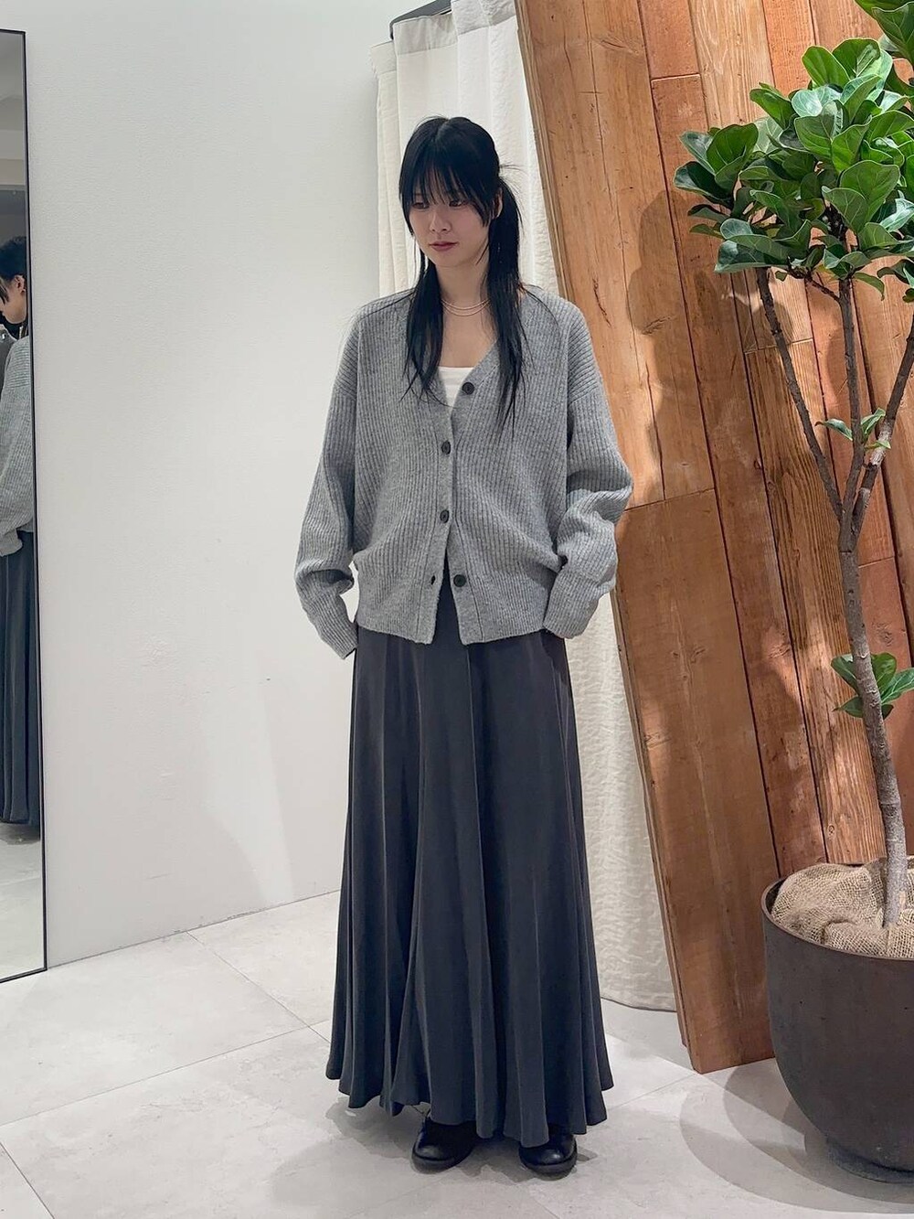 ホワイト系のキャミソール、グレー系のスカート、グレー系のカーディガン/ボレロを着用したレディースの冬コーディネートの4枚目の写真