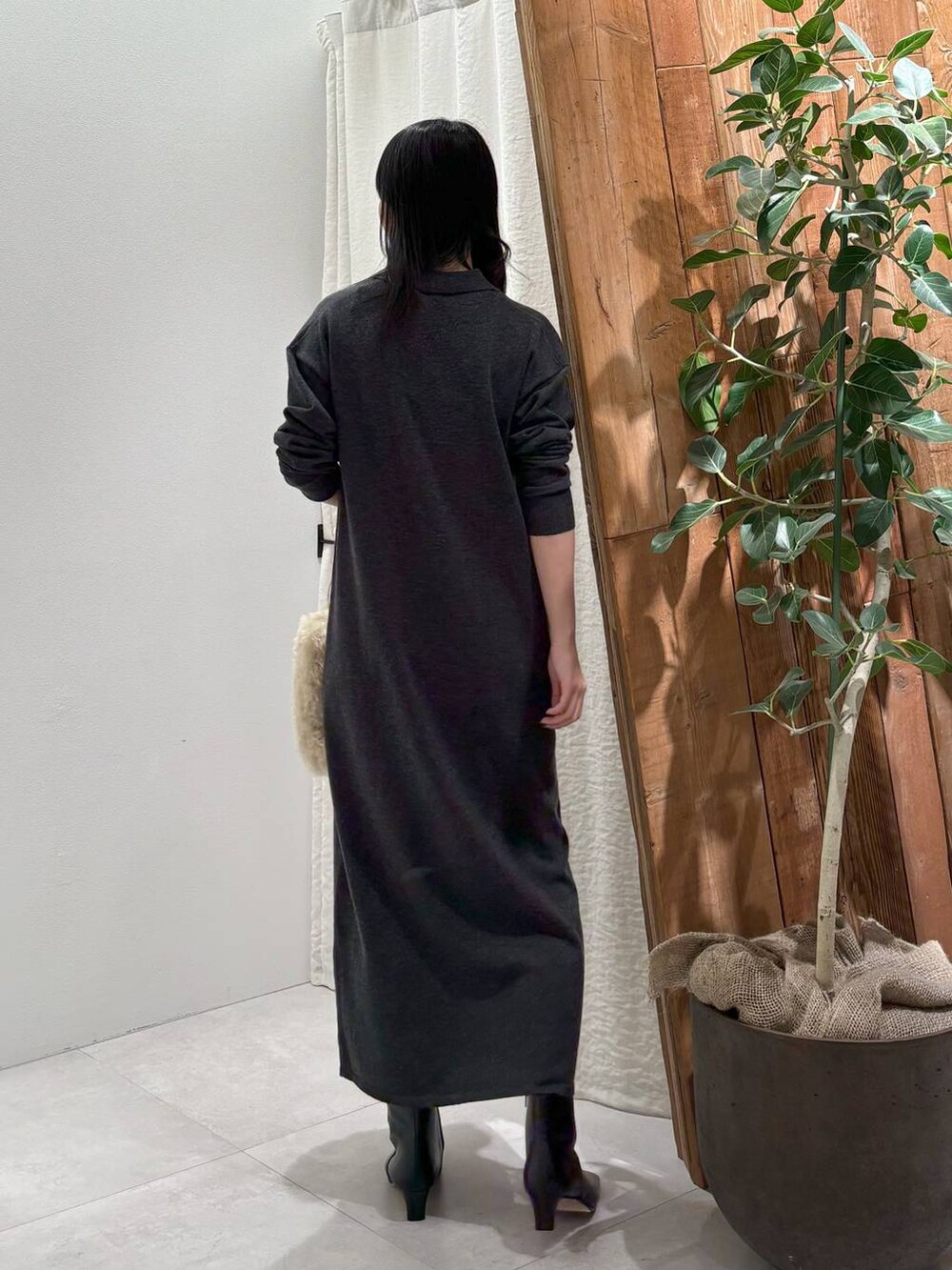 ホワイト系のハンドバッグ、グレー系のワンピースを着用したレディースの秋コーディネートの4枚目の写真