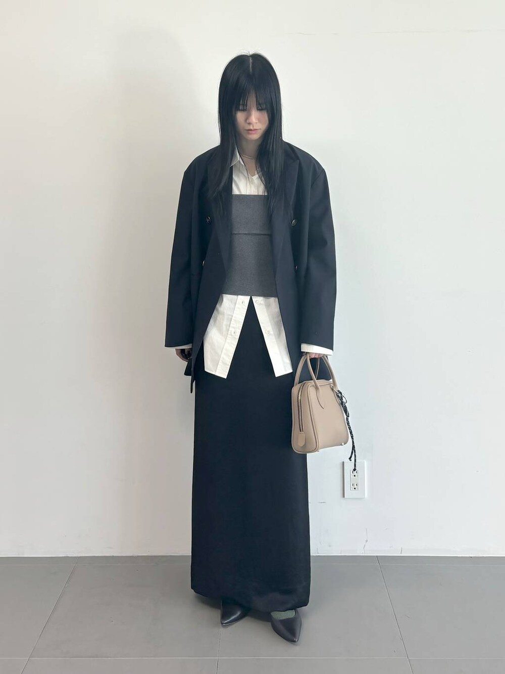 ホワイト系のシャツ/ブラウス、ブルー系のテーラードジャケット、ブラック系のスカートを着用したレディースの冬コーディネートの4枚目の写真