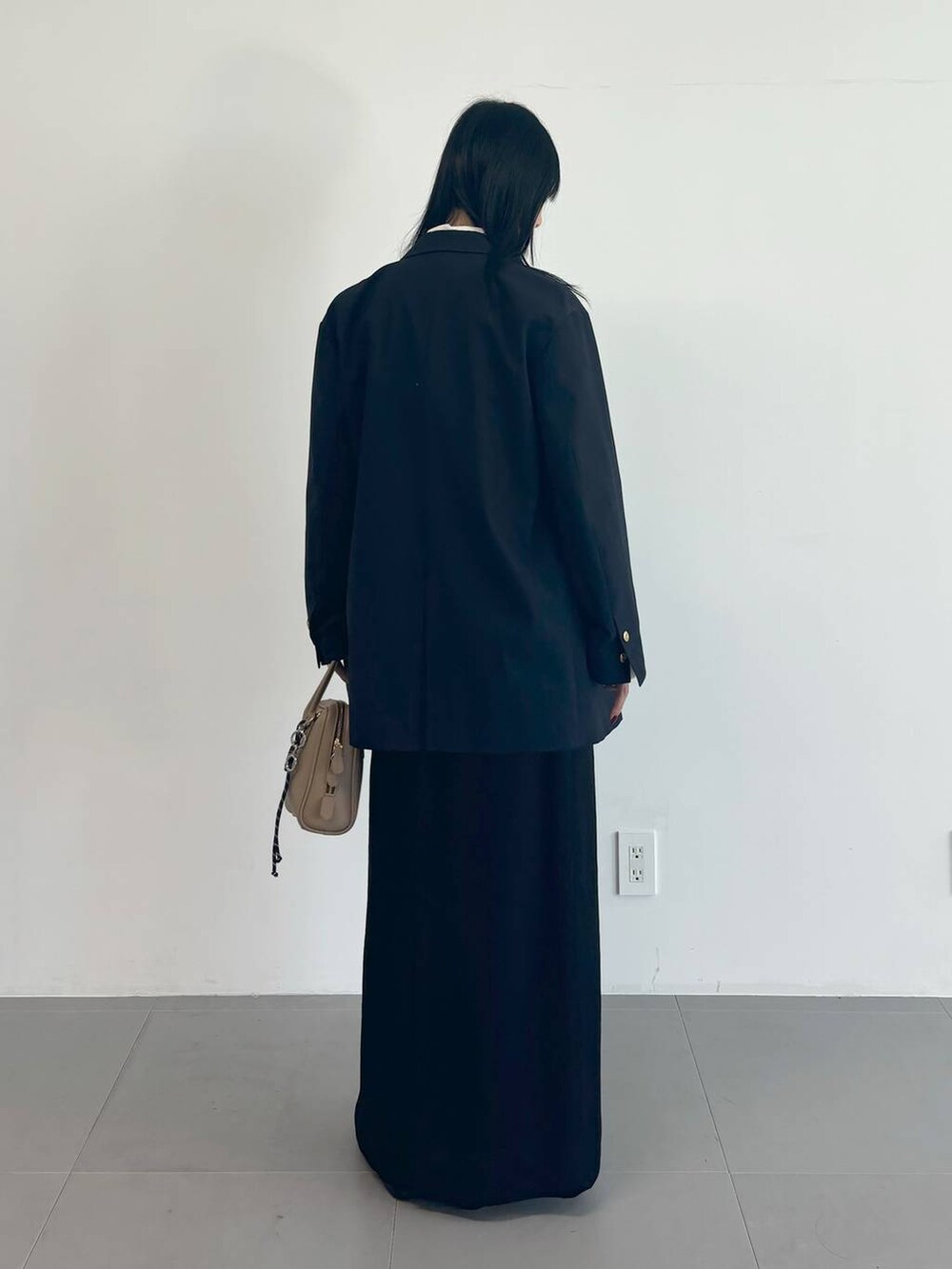 ホワイト系のシャツ/ブラウス、ブルー系のテーラードジャケット、ブラック系のスカートを着用したレディースの冬コーディネートの3枚目の写真