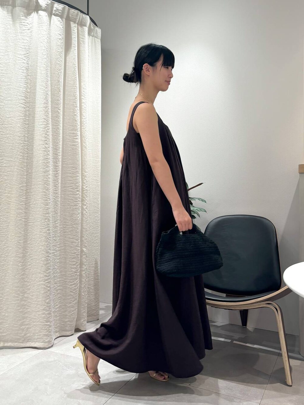 ブラウン系のワンピース、ゴールド系のサンダル、ゴールド系のブレスレットを着用したレディースの春コーディネートの7枚目の写真