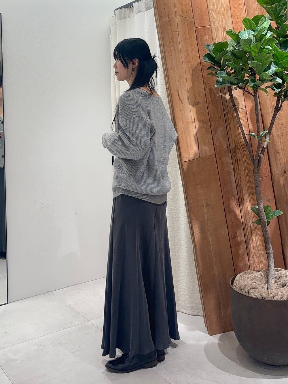 ホワイト系のキャミソール、グレー系のスカート、グレー系のカーディガン/ボレロを着用したレディースの冬コーディネートの2枚目の写真