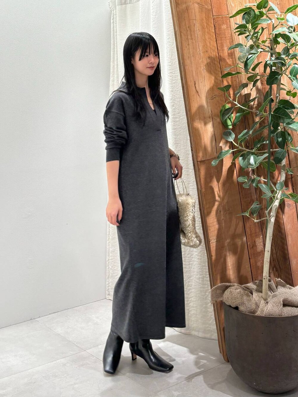 ホワイト系のハンドバッグ、グレー系のワンピースを着用したレディースの秋コーディネートの2枚目の写真