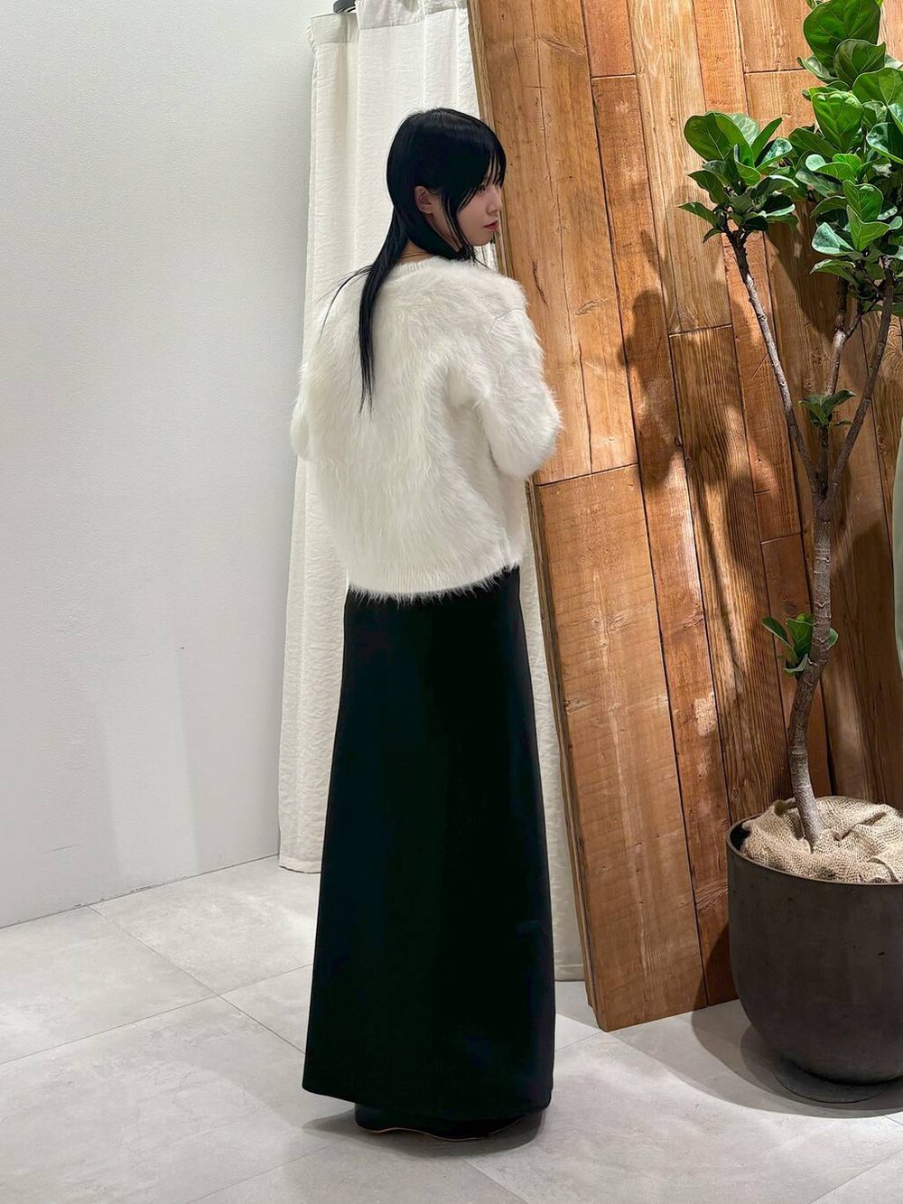 ブラック系のスカート、ホワイト系のカーディガン/ボレロを着用したレディースの秋コーディネートの3枚目の写真