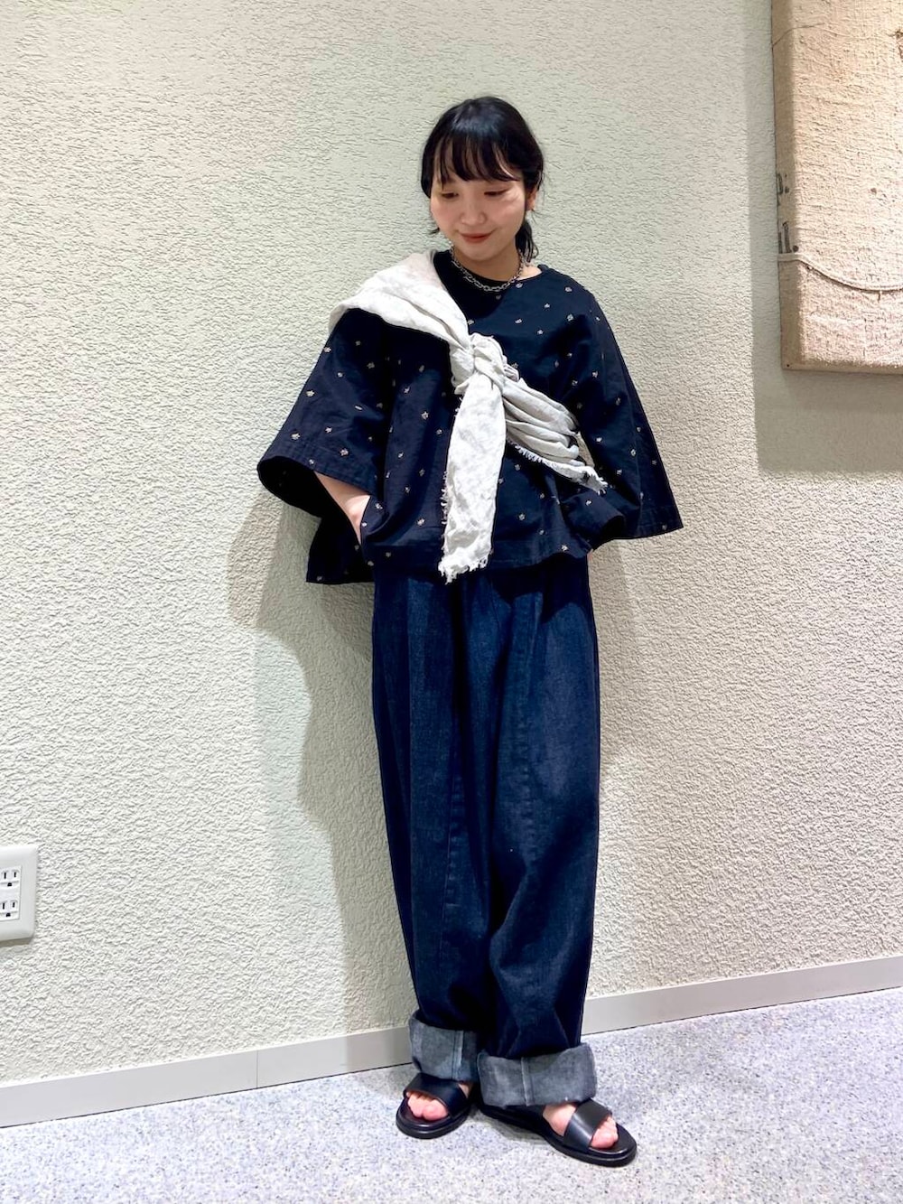 ブルー系のデニムパンツ、ブラック系のシャツ/ブラウス、グレー系のマフラーを着用したレディースの春コーディネートの7枚目の写真