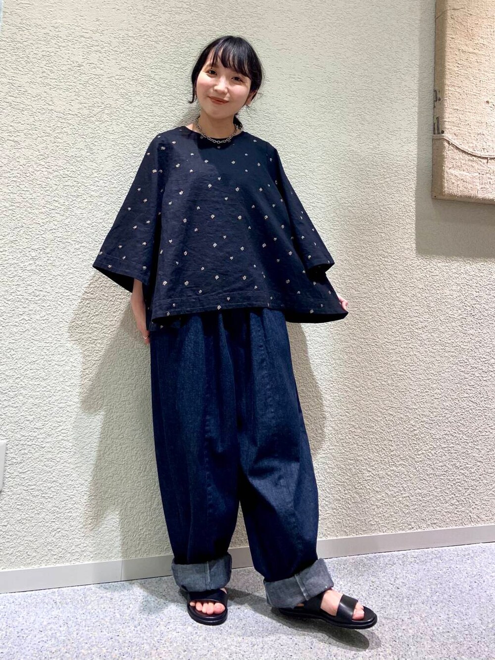 ブルー系のデニムパンツ、ブラック系のシャツ/ブラウス、グレー系のマフラーを着用したレディースの春コーディネートの3枚目の写真