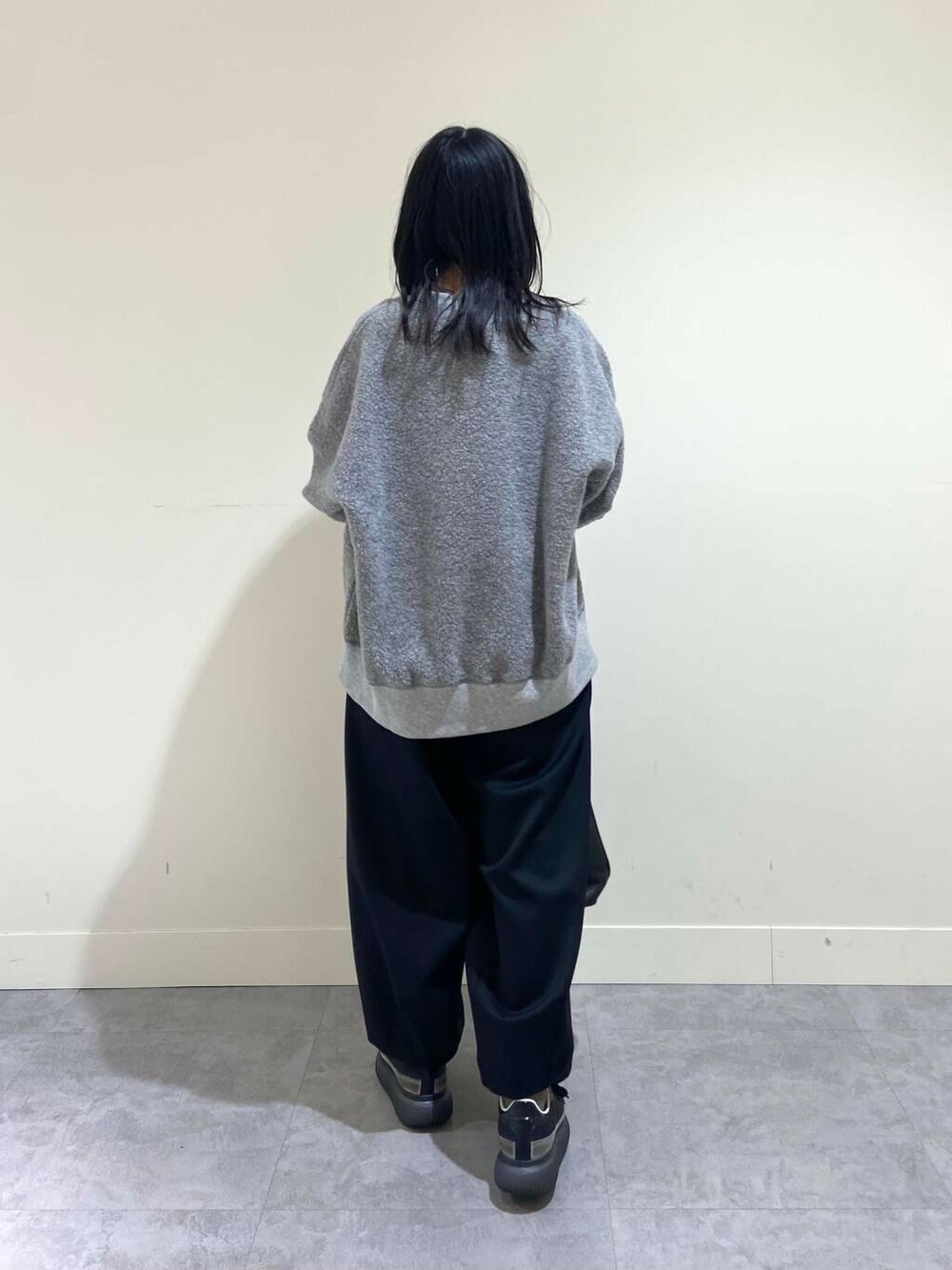 グレー系のTシャツ/カットソー、ブラック系のその他パンツ、ブラック系のトートバッグを着用したレディースの冬コーディネートの4枚目の写真