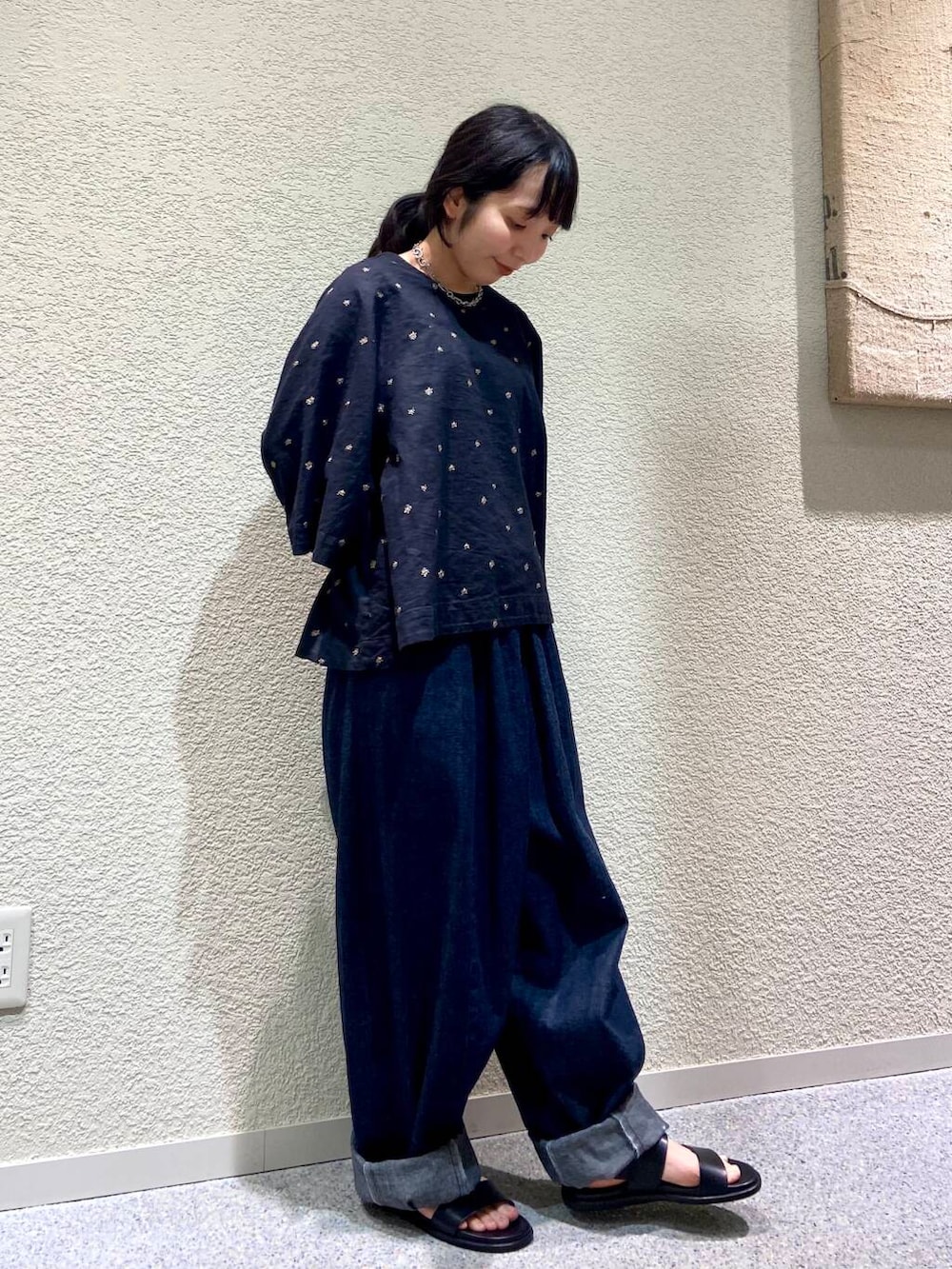 ブルー系のデニムパンツ、ブラック系のシャツ/ブラウス、グレー系のマフラーを着用したレディースの春コーディネートの4枚目の写真