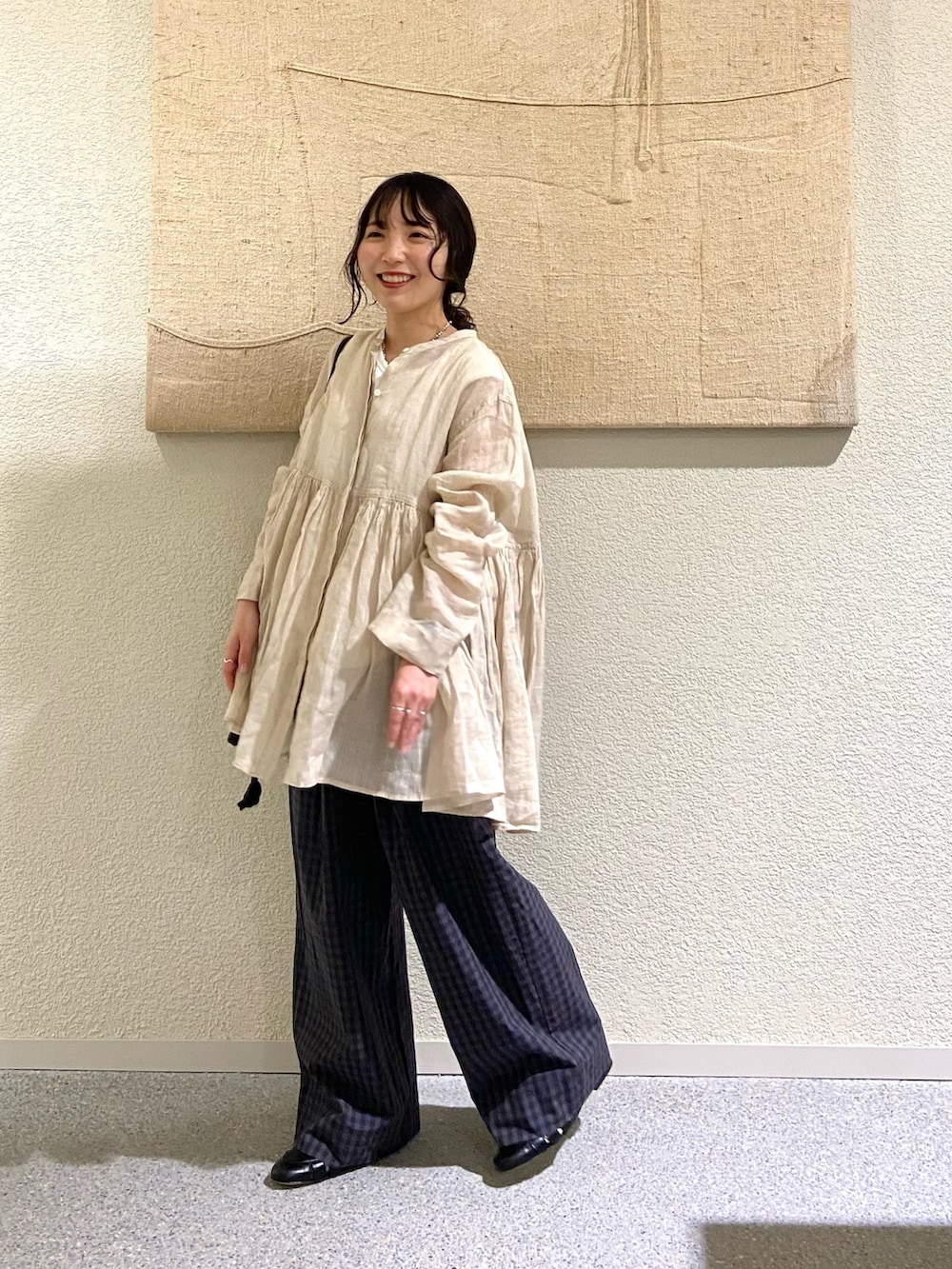 ベージュ系のシャツ/ブラウス、グレー系のその他パンツ、ブラック系のショルダーバッグを着用したレディースの春コーディネートの3枚目の写真