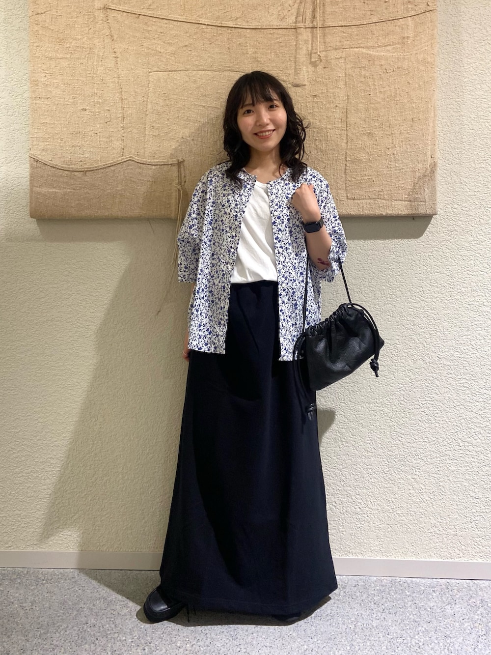 ホワイト系のカーディガン/ボレロ、ホワイト系のタンクトップ、ブラック系のスカートを着用したレディースの夏コーディネートの6枚目の写真
