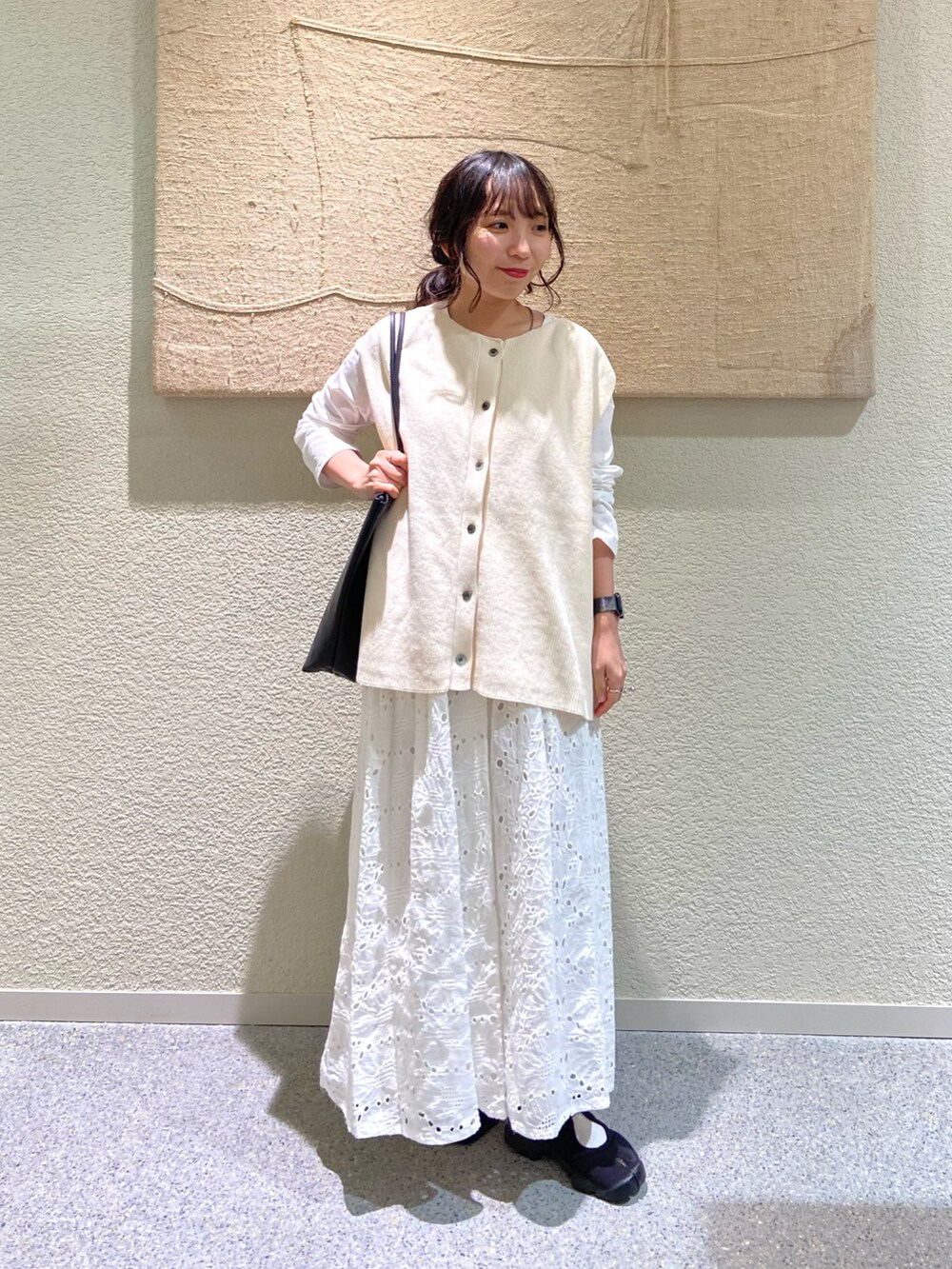 ホワイト系のベスト、ホワイト系のスカート、ホワイト系のTシャツ/カットソーを着用したレディースの秋コーディネートの6枚目の写真