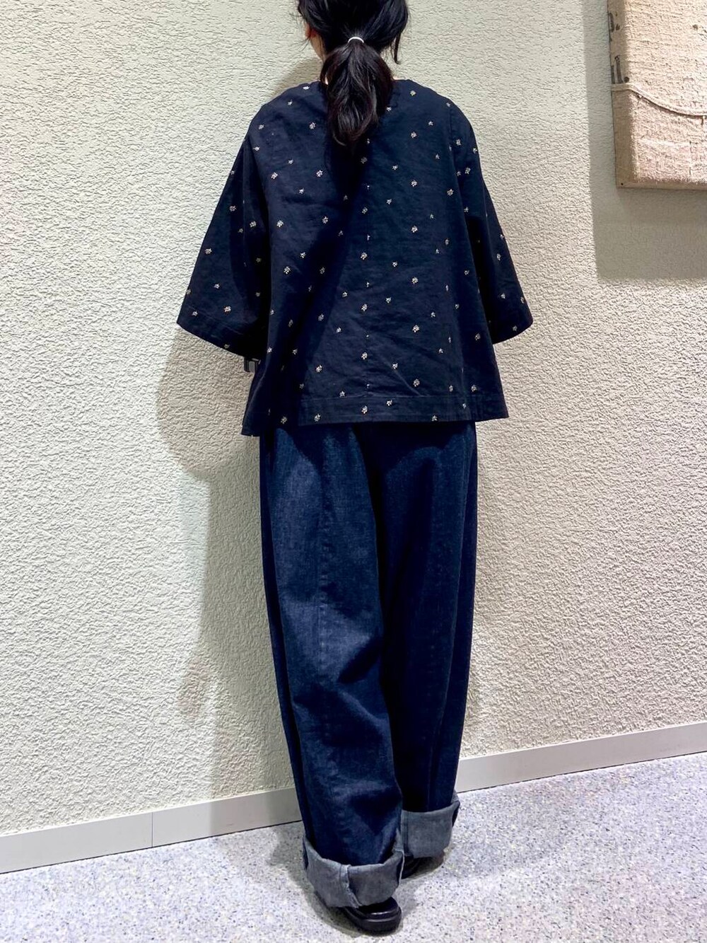 ブルー系のデニムパンツ、ブラック系のシャツ/ブラウス、グレー系のマフラーを着用したレディースの春コーディネートの5枚目の写真