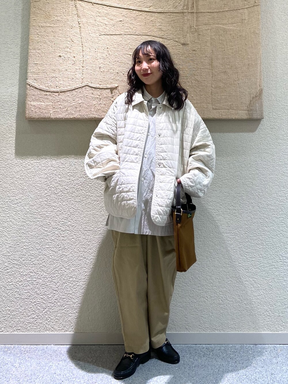 グレー系のシャツ/ブラウス、ホワイト系のダウンジャケット/コート、グレー系のシャツ/ブラウスを着用したレディースの冬コーディネートの2枚目の写真