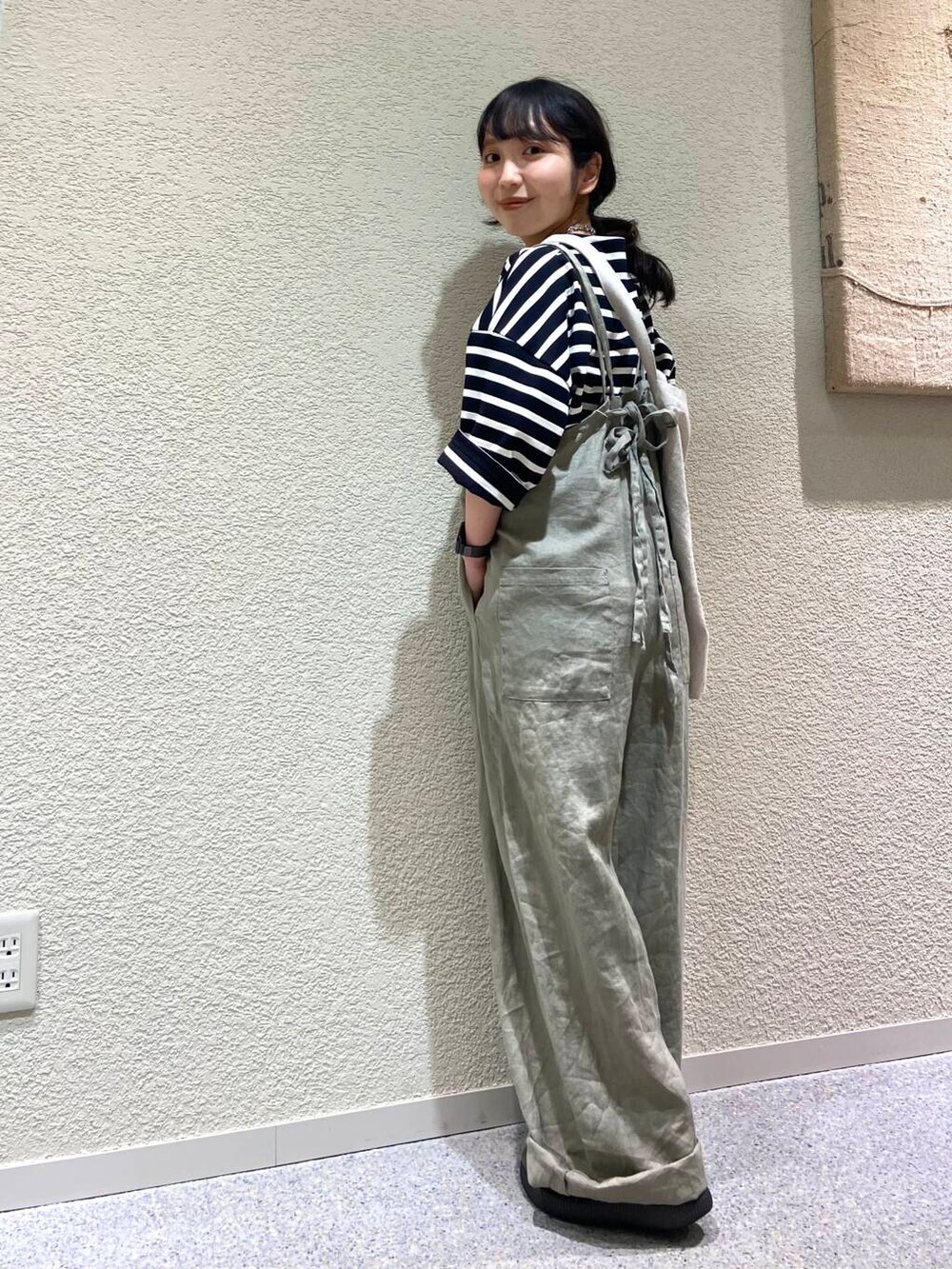 ベージュ系のサロペット/オーバーオール、ベージュ系のトートバッグ、ブラック系のTシャツ/カットソーを着用したレディースの春コーディネートの2枚目の写真