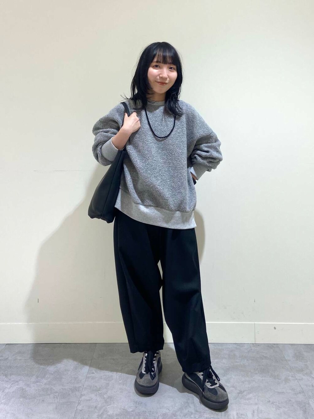 グレー系のTシャツ/カットソー、ブラック系のその他パンツ、ブラック系のトートバッグを着用したレディースの冬コーディネートの5枚目の写真