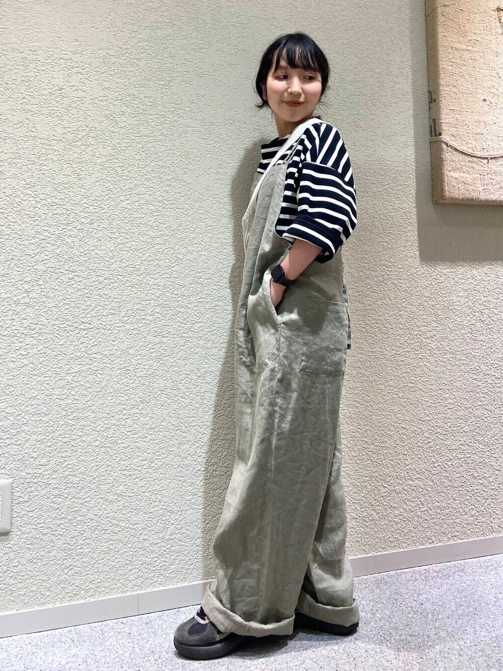 ベージュ系のサロペット/オーバーオール、ベージュ系のトートバッグ、ブラック系のTシャツ/カットソーを着用したレディースの春コーディネートの3枚目の写真