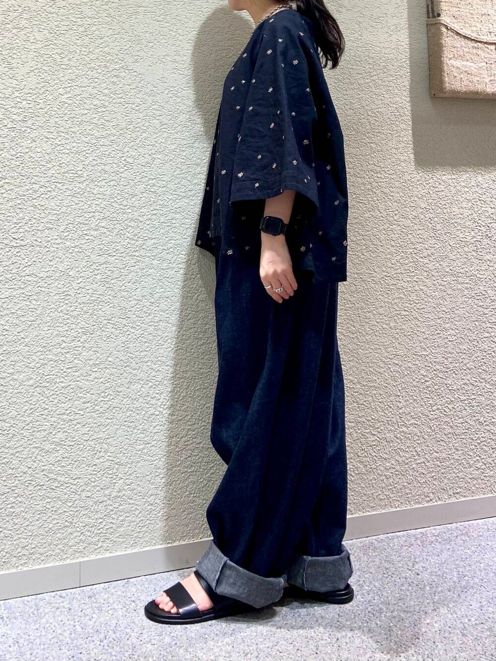 ブルー系のデニムパンツ、ブラック系のシャツ/ブラウス、グレー系のマフラーを着用したレディースの春コーディネートの6枚目の写真