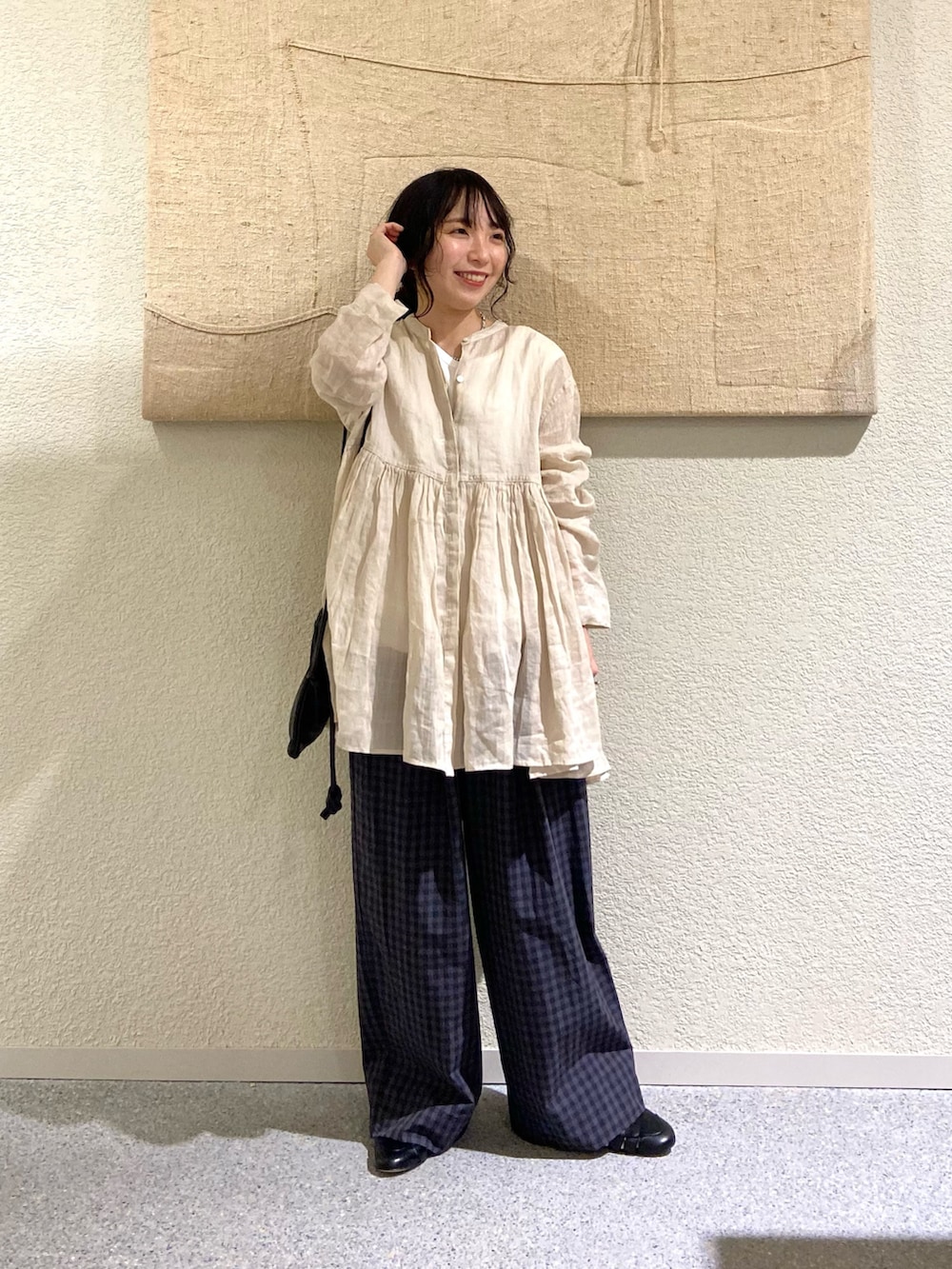 ベージュ系のシャツ/ブラウス、グレー系のその他パンツ、ブラック系のショルダーバッグを着用したレディースの春コーディネートの2枚目の写真