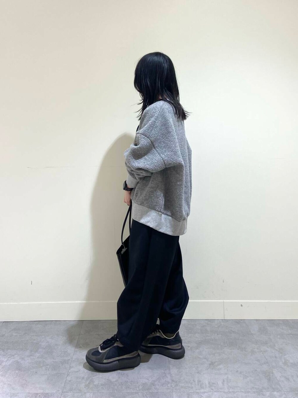 グレー系のTシャツ/カットソー、ブラック系のその他パンツ、ブラック系のトートバッグを着用したレディースの冬コーディネートの3枚目の写真