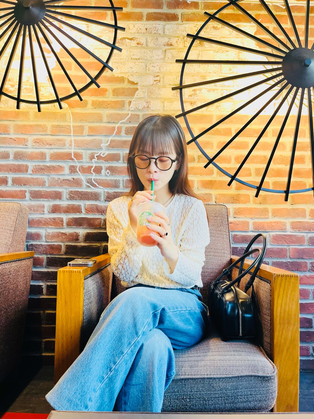 ブラック系のボストンバッグ、ブルー系のデニムパンツ、ホワイト系のTシャツ/カットソーを着用したレディースの夏コーディネートの2枚目の写真