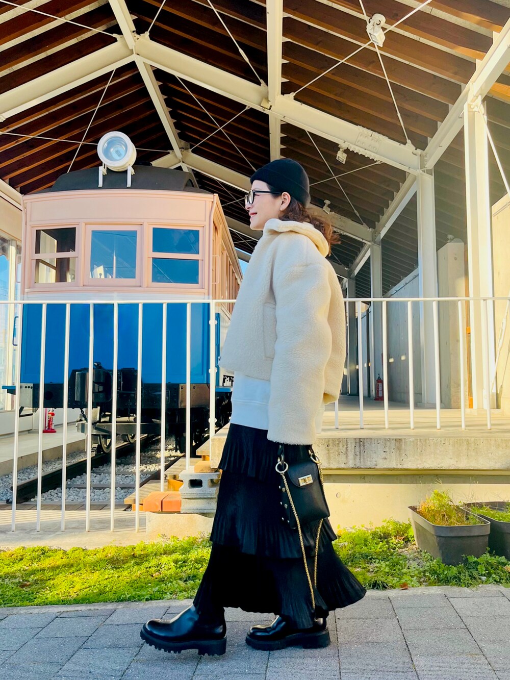 ホワイト系のその他アウター、ブラック系のクラッチバッグ、ブラック系のスカートを着用したレディースの冬コーディネートの3枚目の写真