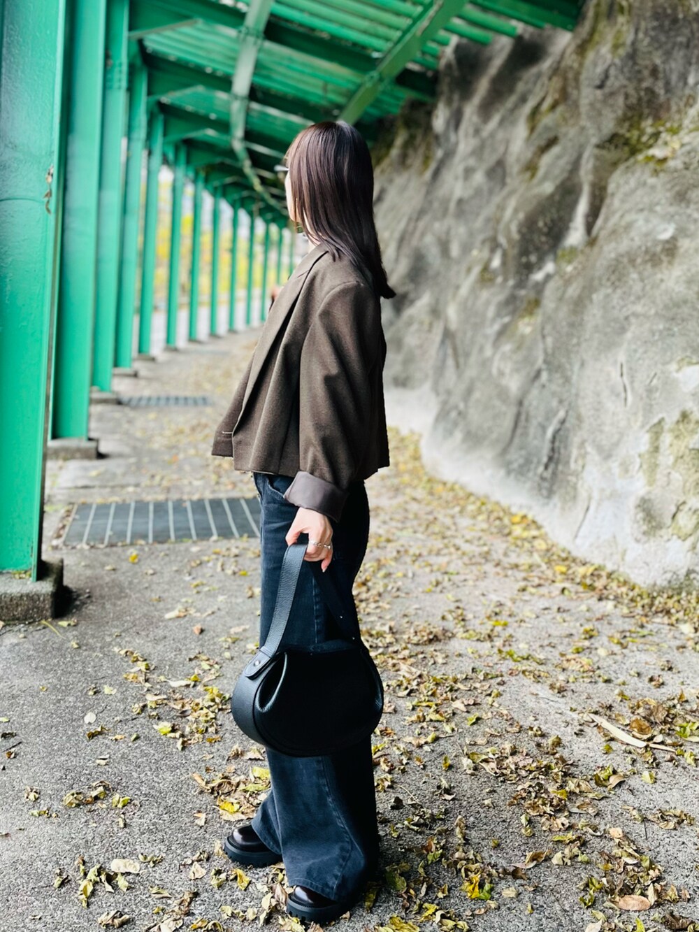 ブラウン系のキャミソール、ブラウン系のテーラードジャケット、ブラック系のハンドバッグを着用したレディースの冬コーディネートの2枚目の写真