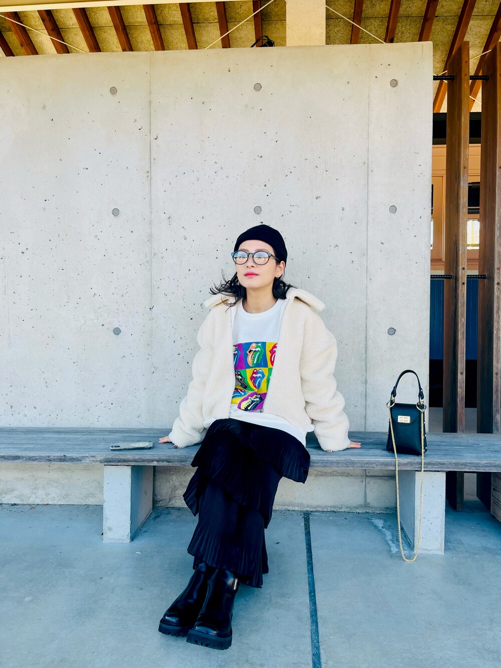 ホワイト系のその他アウター、ブラック系のクラッチバッグ、ブラック系のスカートを着用したレディースの冬コーディネートの2枚目の写真