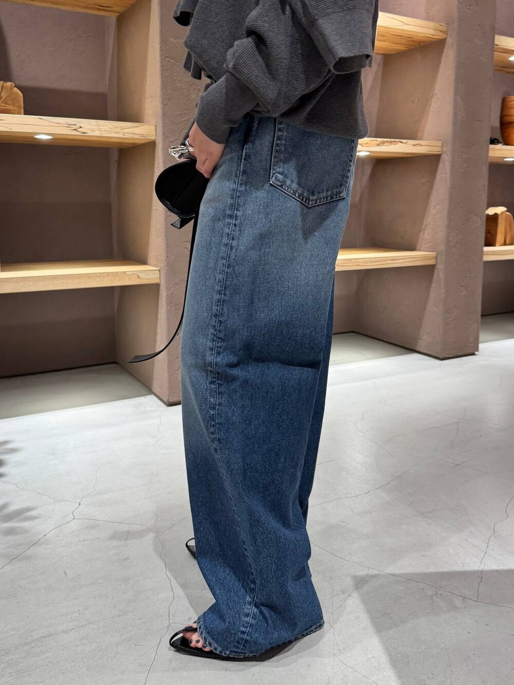 ブルー系のデニムパンツ、グレー系のニット/セーター、グレー系のカーディガン/ボレロを着用したレディースの夏コーディネートの9枚目の写真