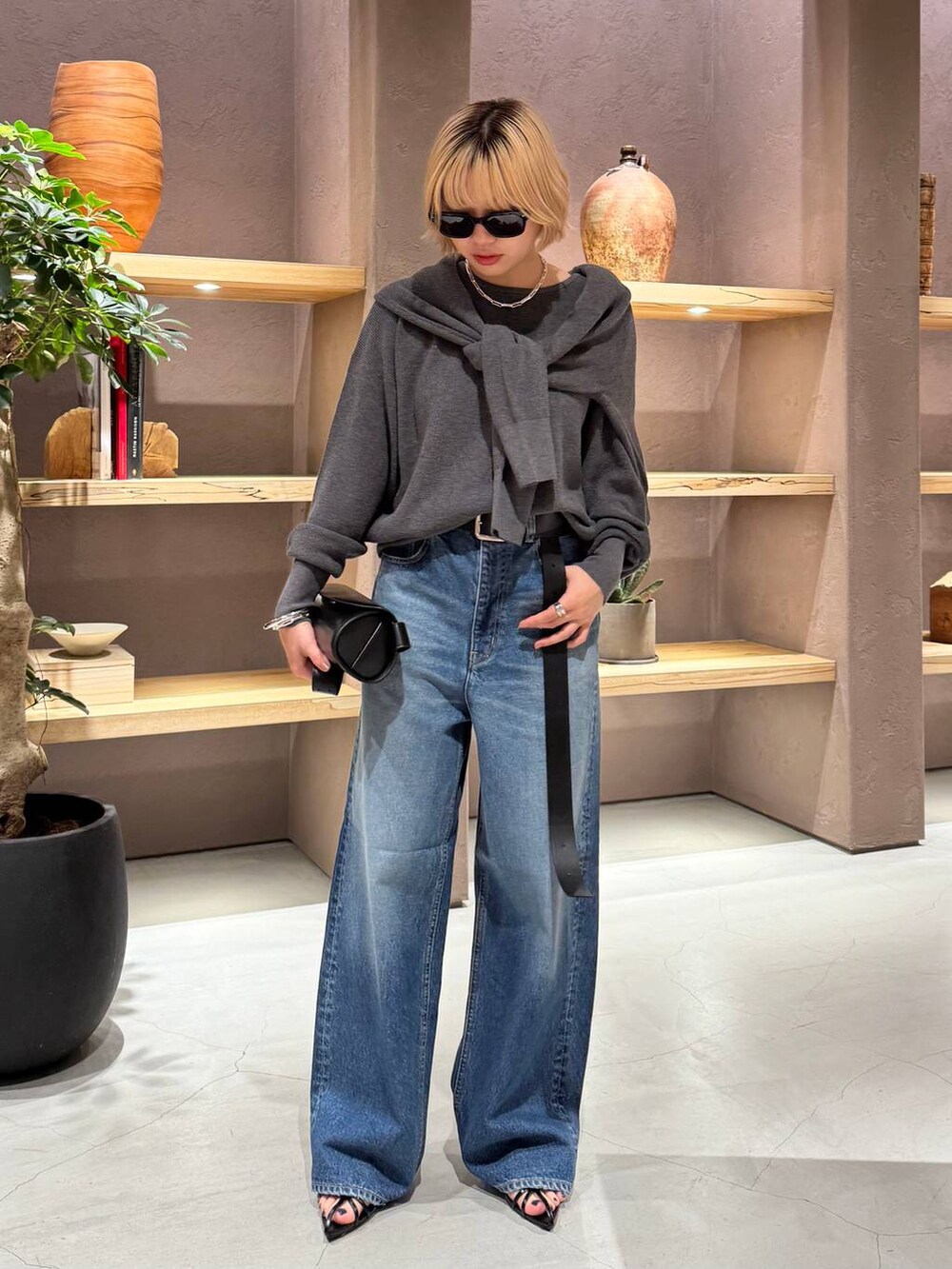 ブルー系のデニムパンツ、グレー系のニット/セーター、グレー系のカーディガン/ボレロを着用したレディースの夏コーディネートの4枚目の写真