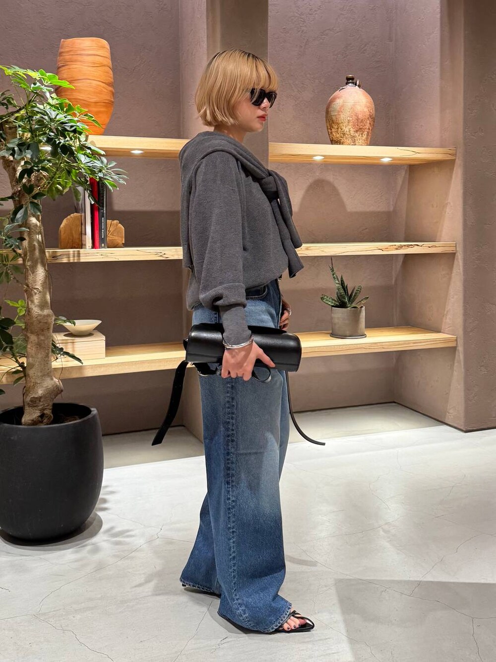 ブルー系のデニムパンツ、グレー系のニット/セーター、グレー系のカーディガン/ボレロを着用したレディースの夏コーディネートの2枚目の写真