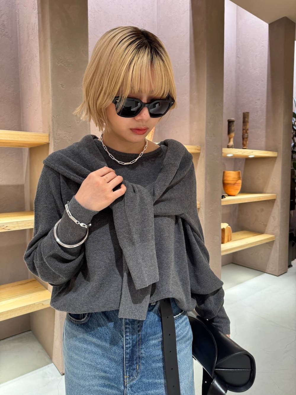 ブルー系のデニムパンツ、グレー系のニット/セーター、グレー系のカーディガン/ボレロを着用したレディースの夏コーディネートの5枚目の写真