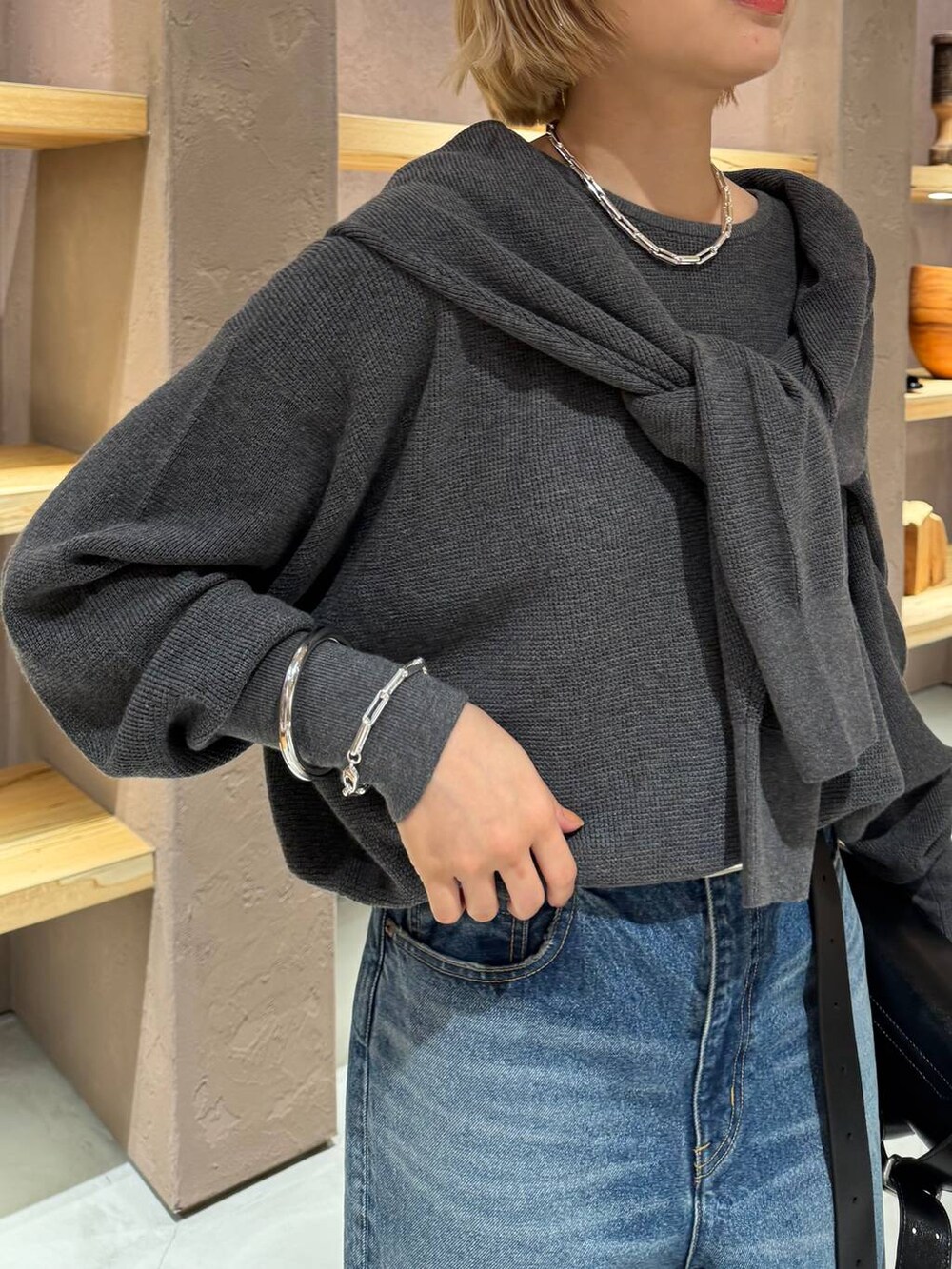 ブルー系のデニムパンツ、グレー系のニット/セーター、グレー系のカーディガン/ボレロを着用したレディースの夏コーディネートの6枚目の写真