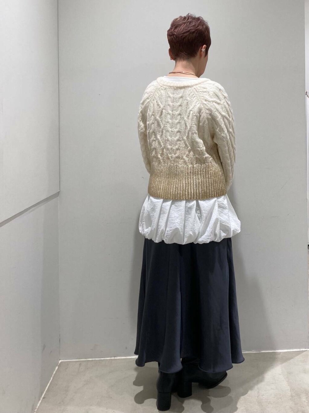 ブラック系のブーツ、グレー系のスカート、ホワイト系のTシャツ/カットソーを着用したレディースの冬コーディネートの6枚目の写真