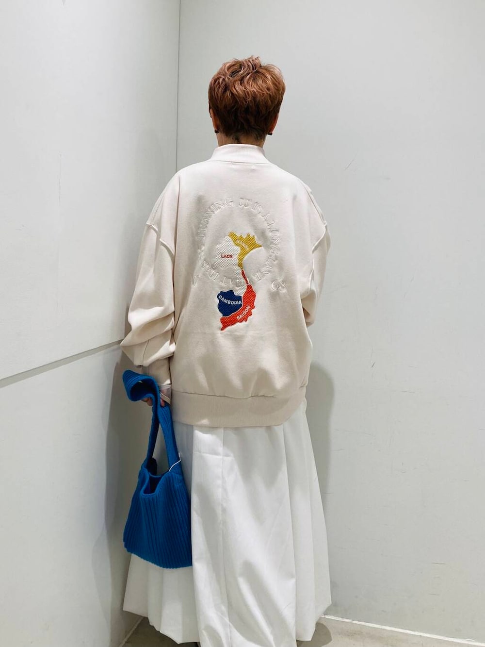 ホワイト系のスカート、ホワイト系のTシャツ/カットソー、ホワイト系のブルゾンを着用したレディースの冬コーディネートの3枚目の写真