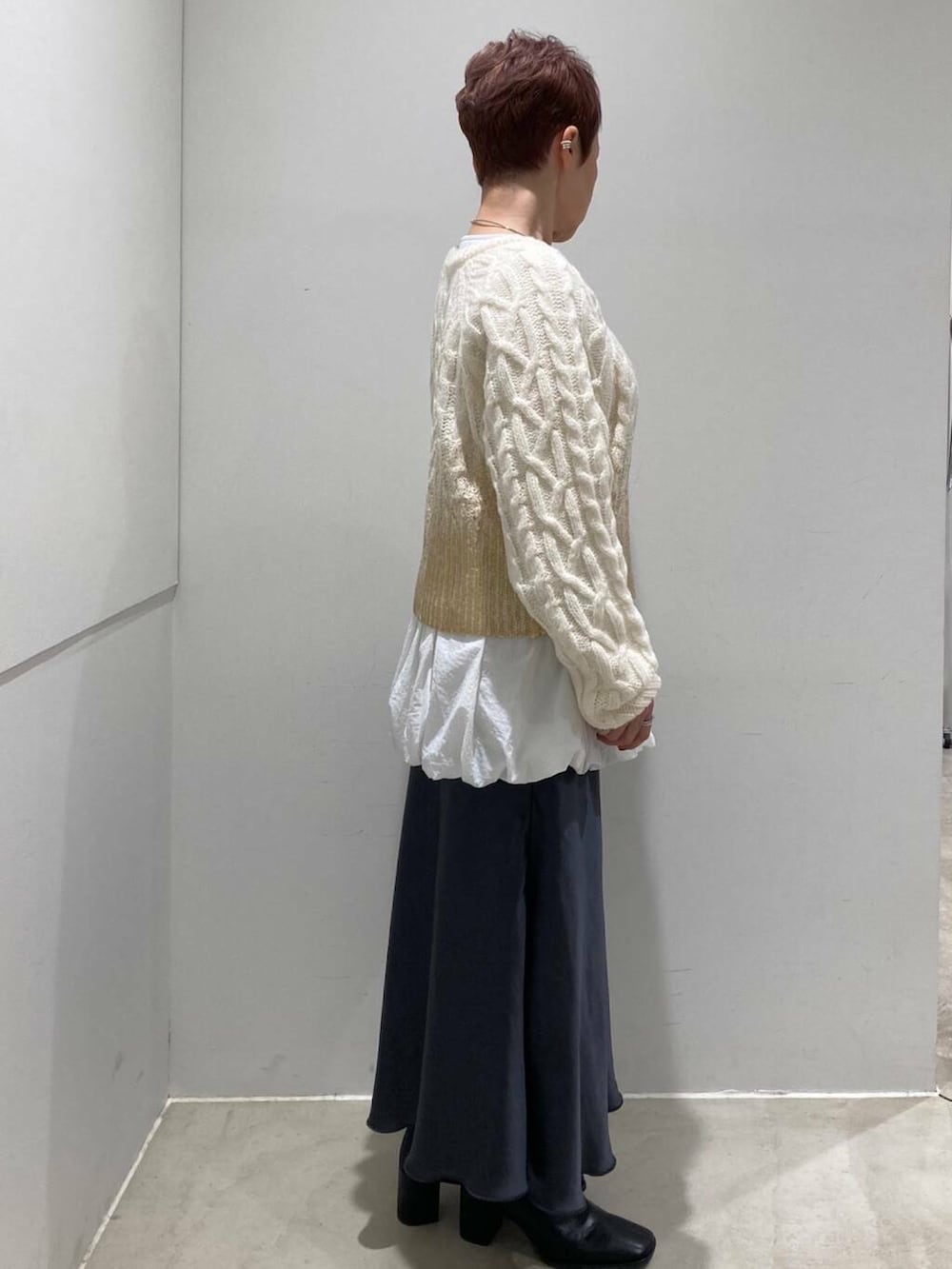 ブラック系のブーツ、グレー系のスカート、ホワイト系のTシャツ/カットソーを着用したレディースの冬コーディネートの5枚目の写真