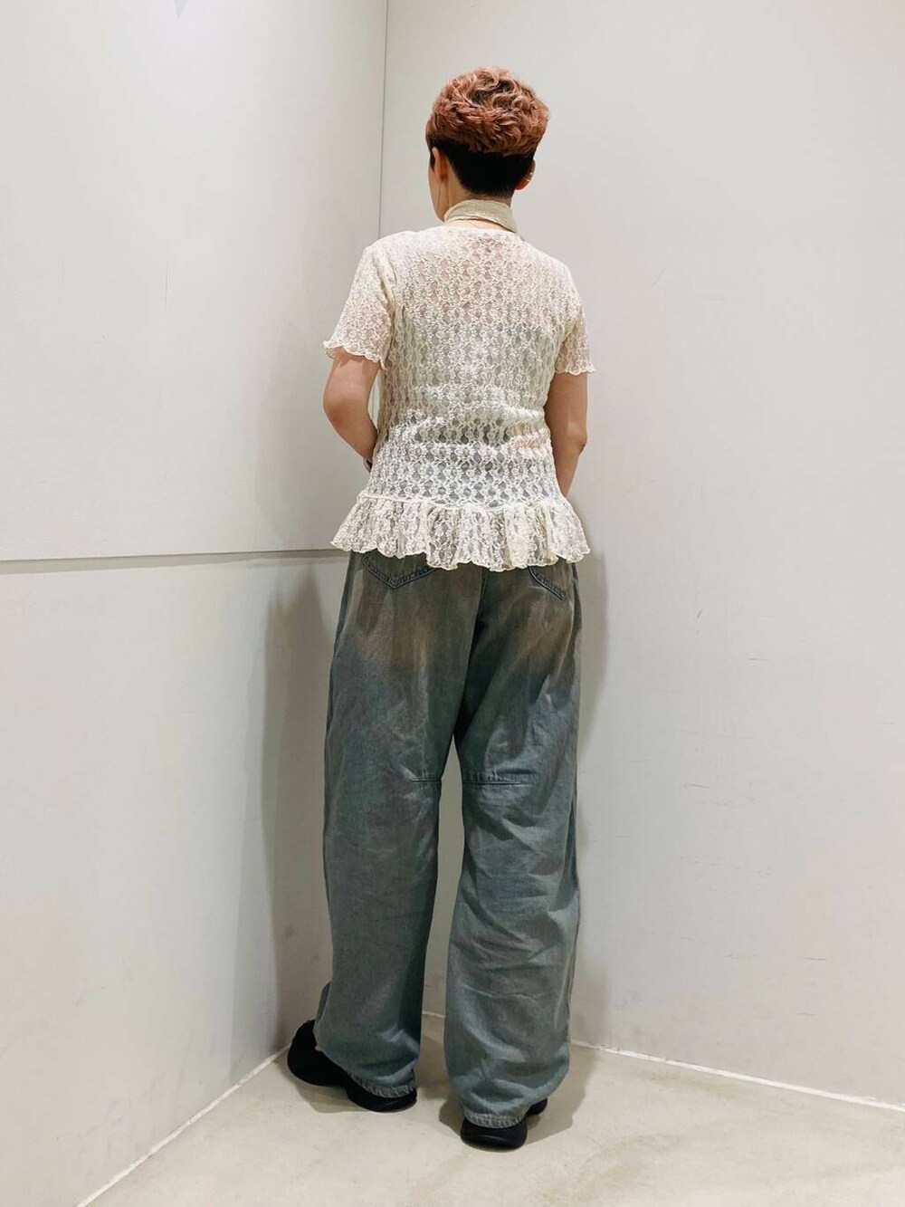 ブラウン系のデニムパンツ、ブラック系のサンダル、グレー系のキャミソールを着用したレディースの夏コーディネートの3枚目の写真