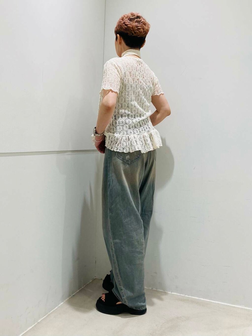 ブラウン系のデニムパンツ、ブラック系のサンダル、グレー系のキャミソールを着用したレディースの夏コーディネートの2枚目の写真