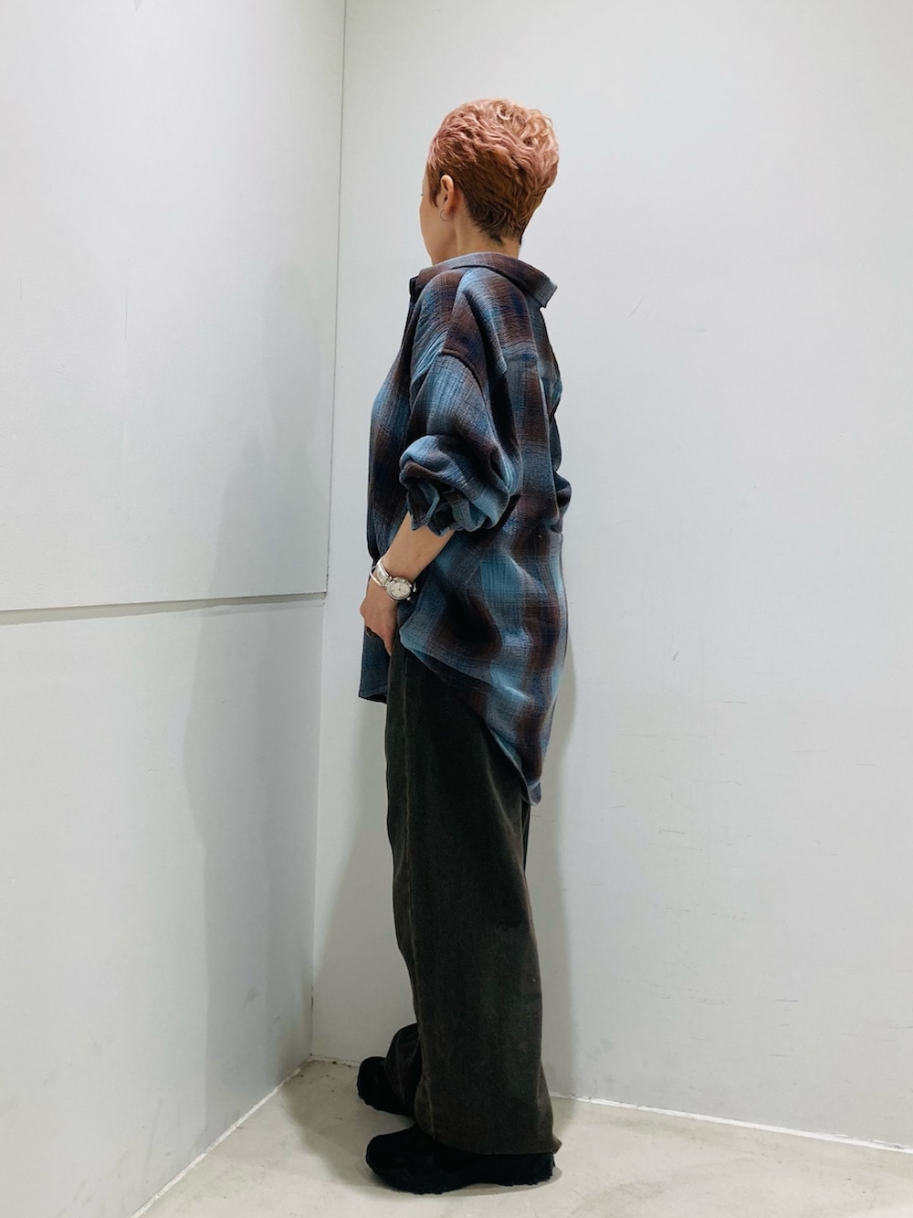 ブラウン系のデニムパンツ、ブルー系のシャツ/ブラウス、ホワイト系のキャミソールを着用したレディースの夏コーディネートの2枚目の写真