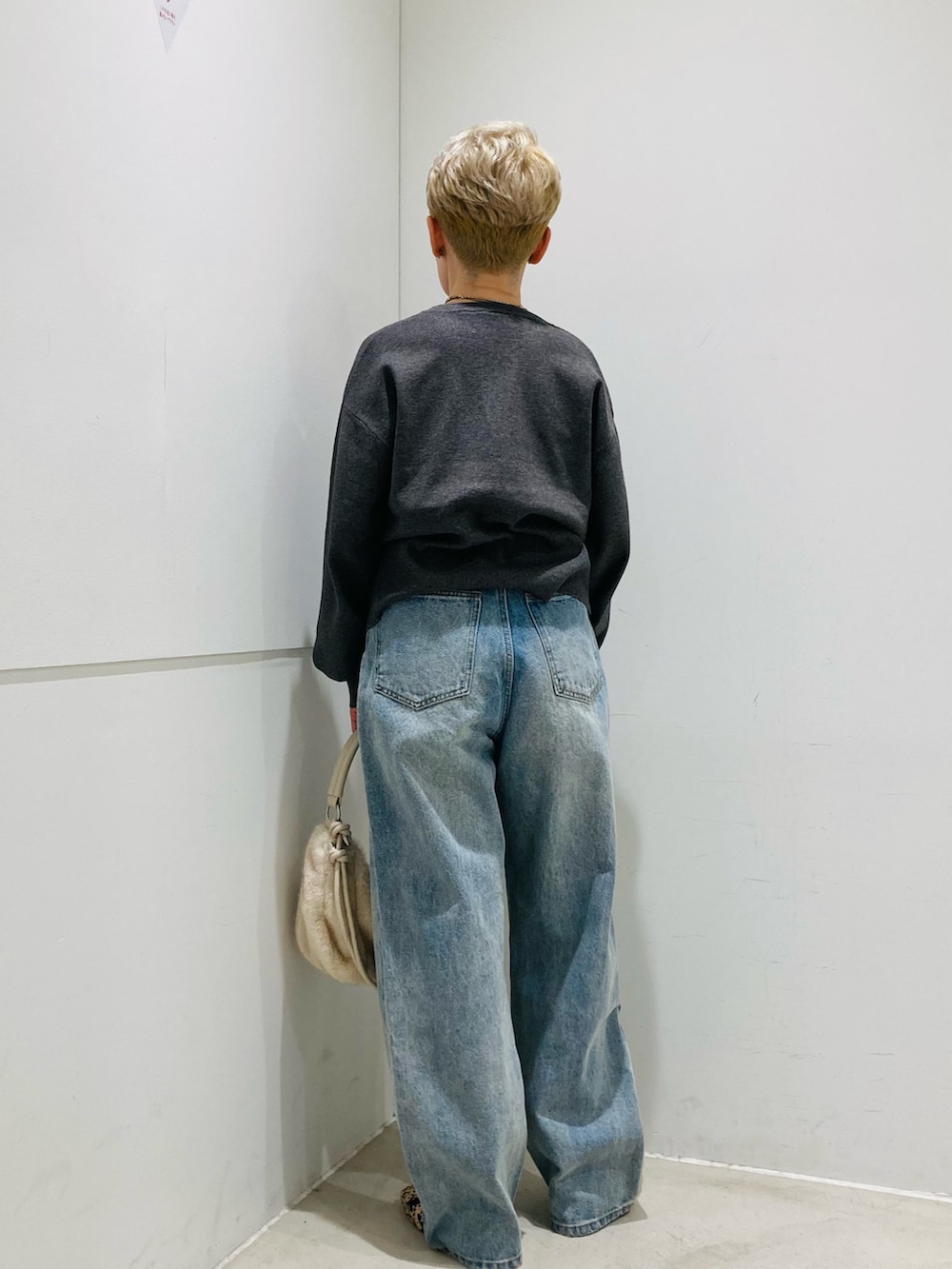 グレー系のカーディガン/ボレロ、ホワイト系のショルダーバッグ、ブルー系のデニムパンツを着用したレディースの秋コーディネートの4枚目の写真