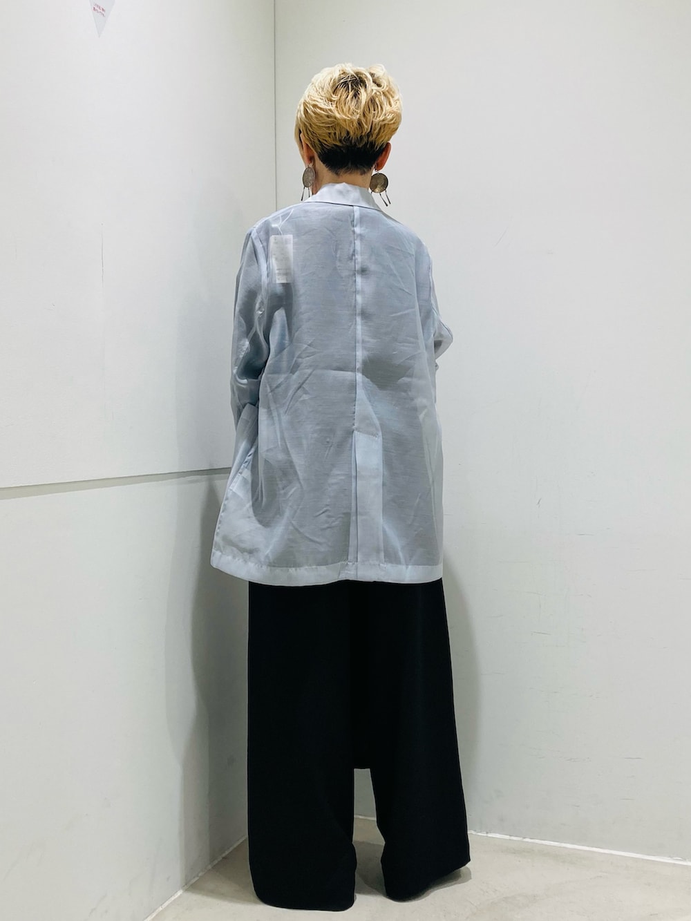 ブラック系のスラックス、ブラック系のショルダーバッグ、ブルー系のテーラードジャケットを着用したレディースの春コーディネートの3枚目の写真