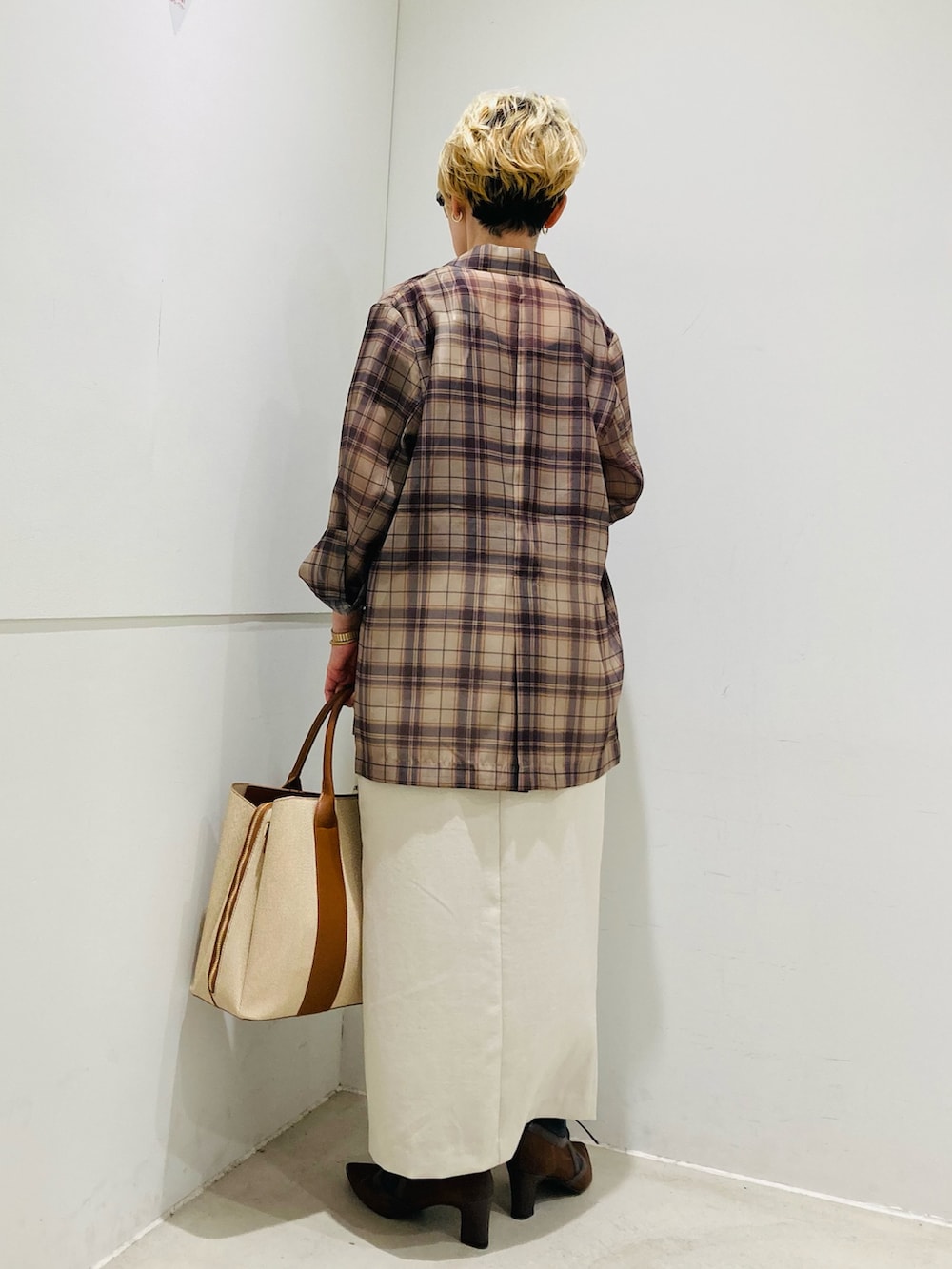 ベージュ系のテーラードジャケット、ブラウン系のTシャツ/カットソー、ベージュ系のスカートを着用したレディースの春コーディネートの3枚目の写真