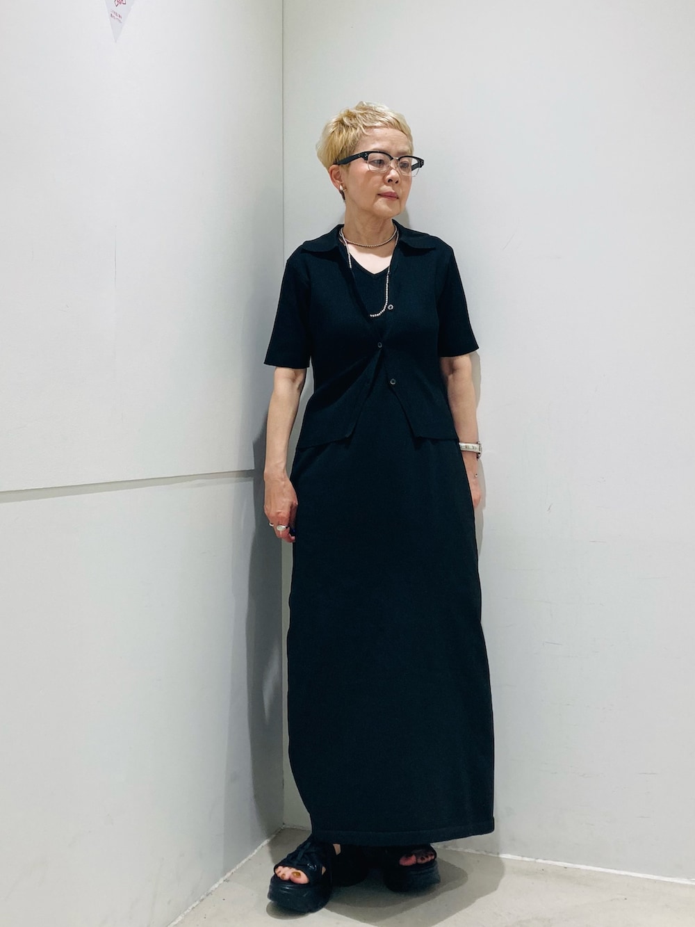 ブルー系のシャツ/ブラウス、ブラック系のサンダル、ブラック系のハンドバッグを着用したレディースの春コーディネートの2枚目の写真